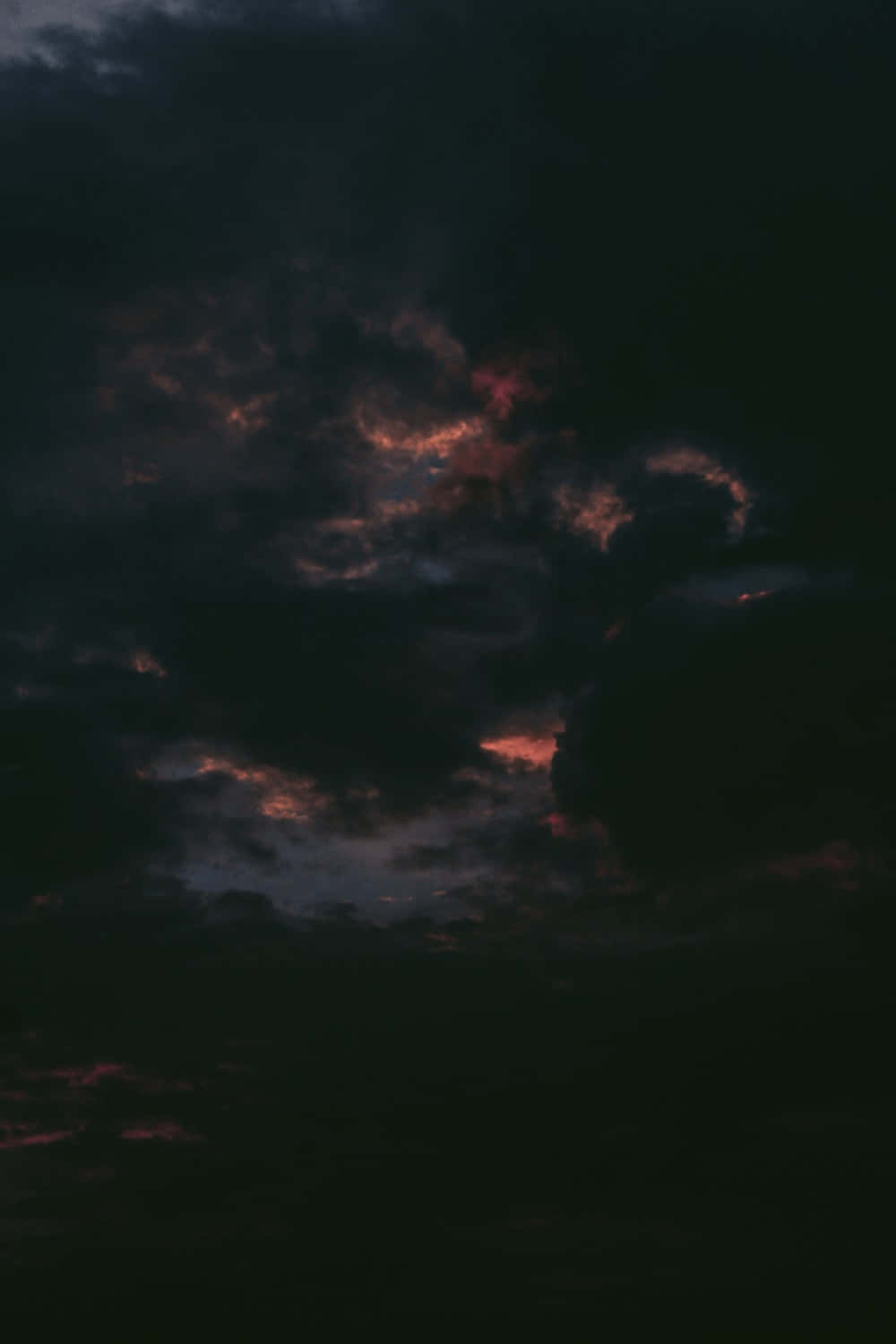 黃昏時被橙色和紅色照亮的暗雲。