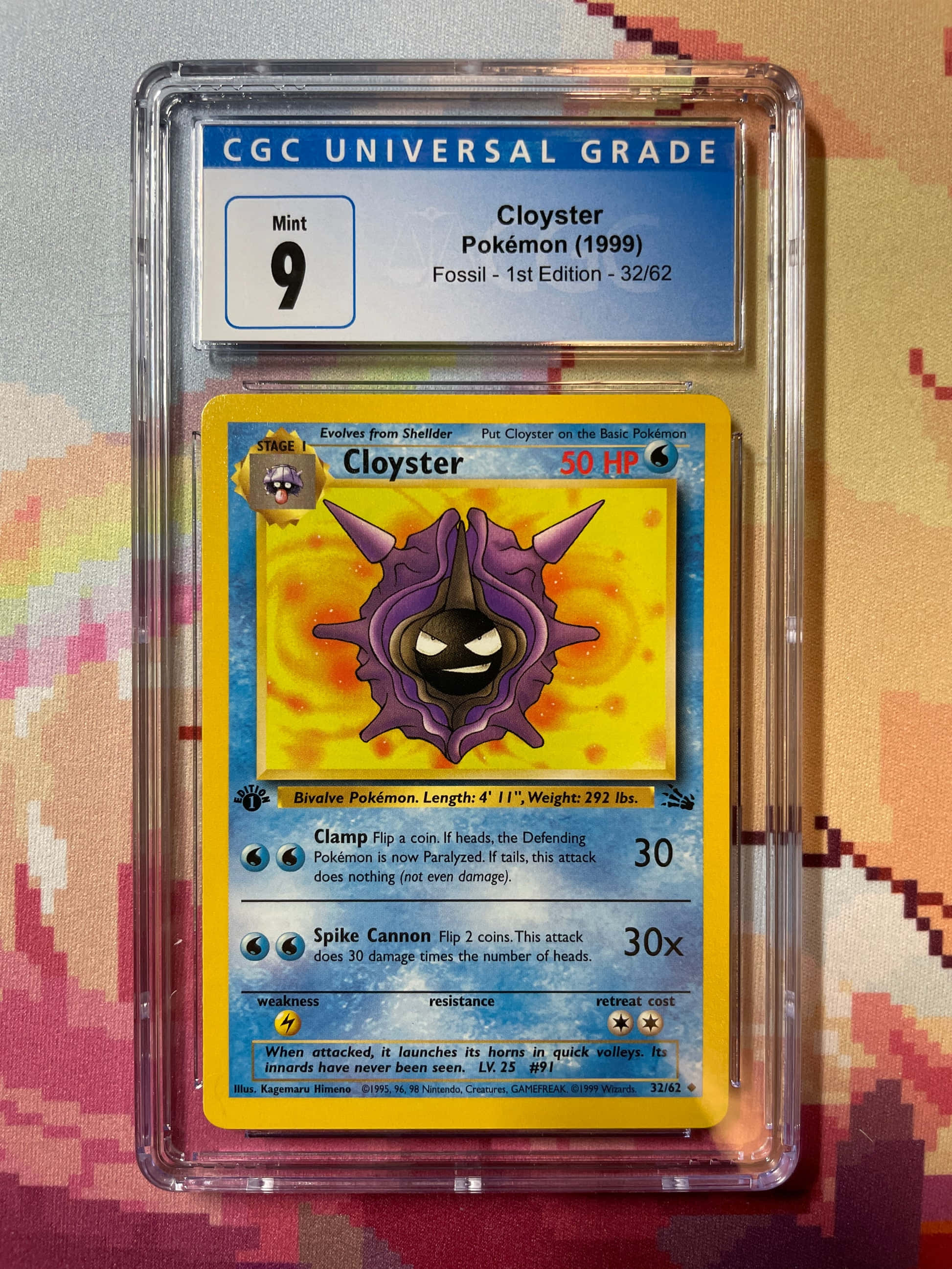 動感 Cloyster 壁紙 — 一張1999年完美無瑕的Cloyster寶可夢卡，經CGC評級為Mint 9，放在透明保護殼中，置於色彩繽紛的圖案布料背景上。