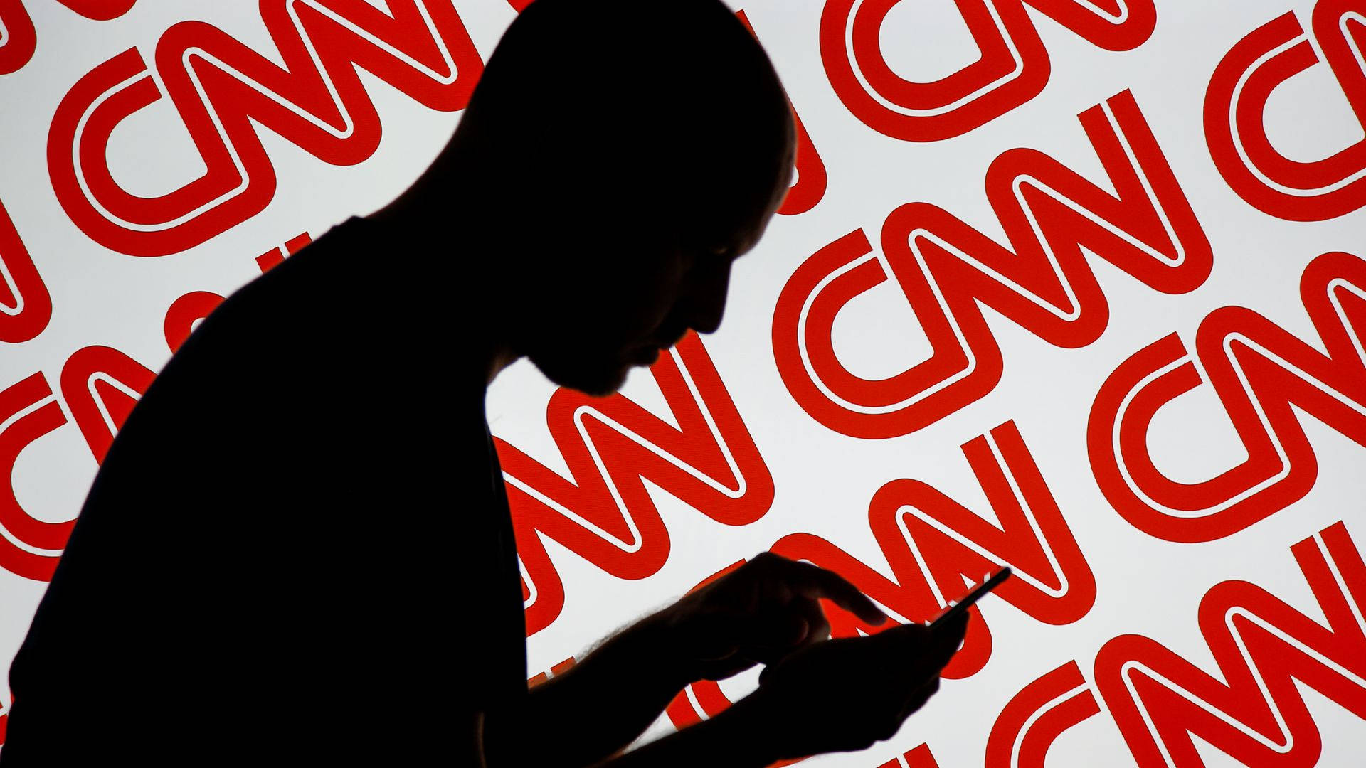 CNN 與 Twitter 合作推廣活動 壁紙 — 一個人使用電話的剪影，背景是重複的紅色CNN標誌。