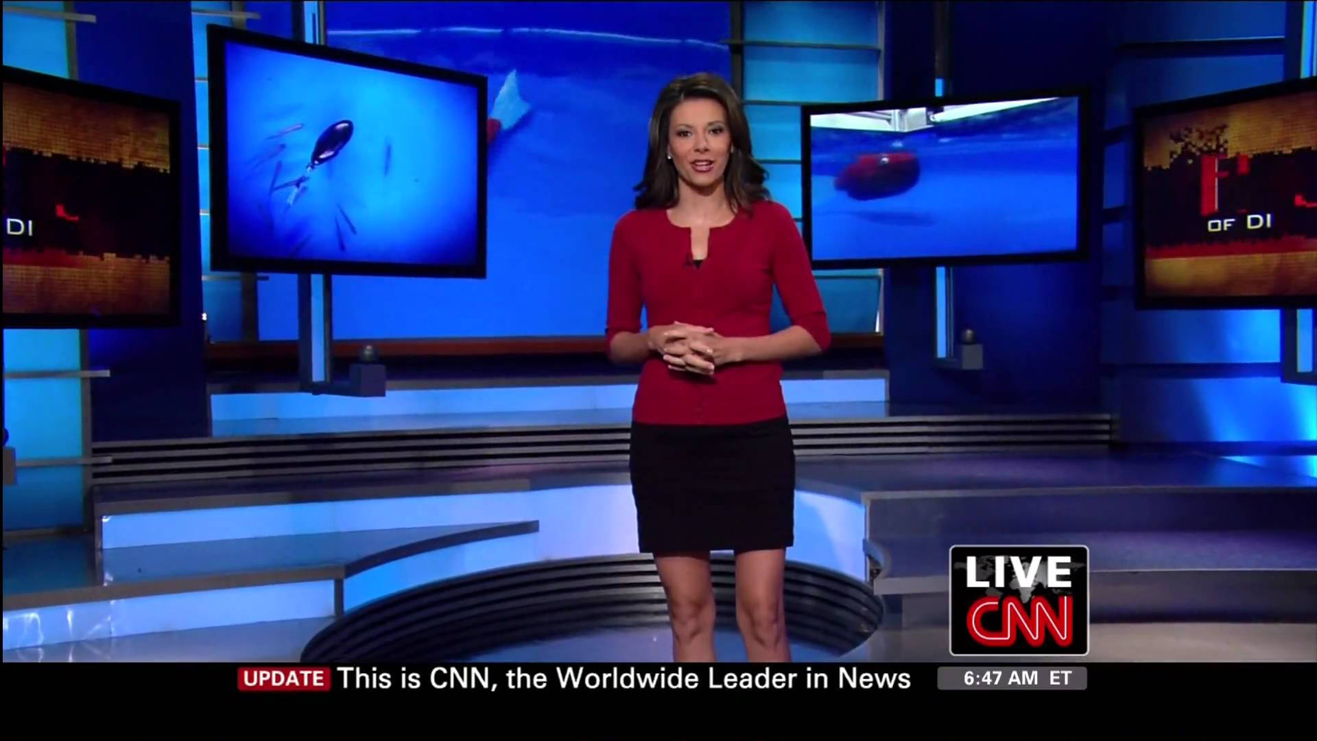 CNN 資深記者基蘭·切特里 壁紙 — 一位身穿紅色上衣的女新聞主播站在CNN攝影棚中央，藍色屏幕顯示著水下畫面。