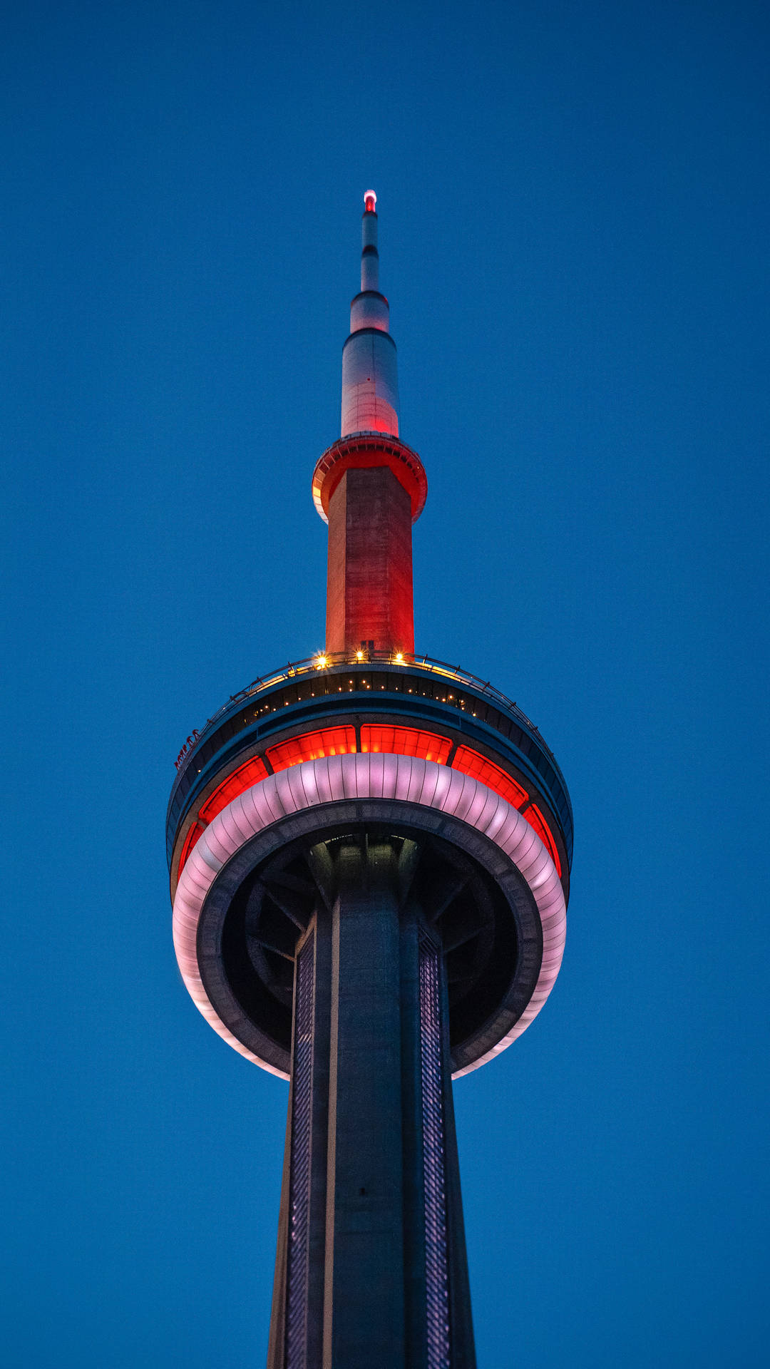 CN塔在暮色天空中以紅色和白色燈光亮起