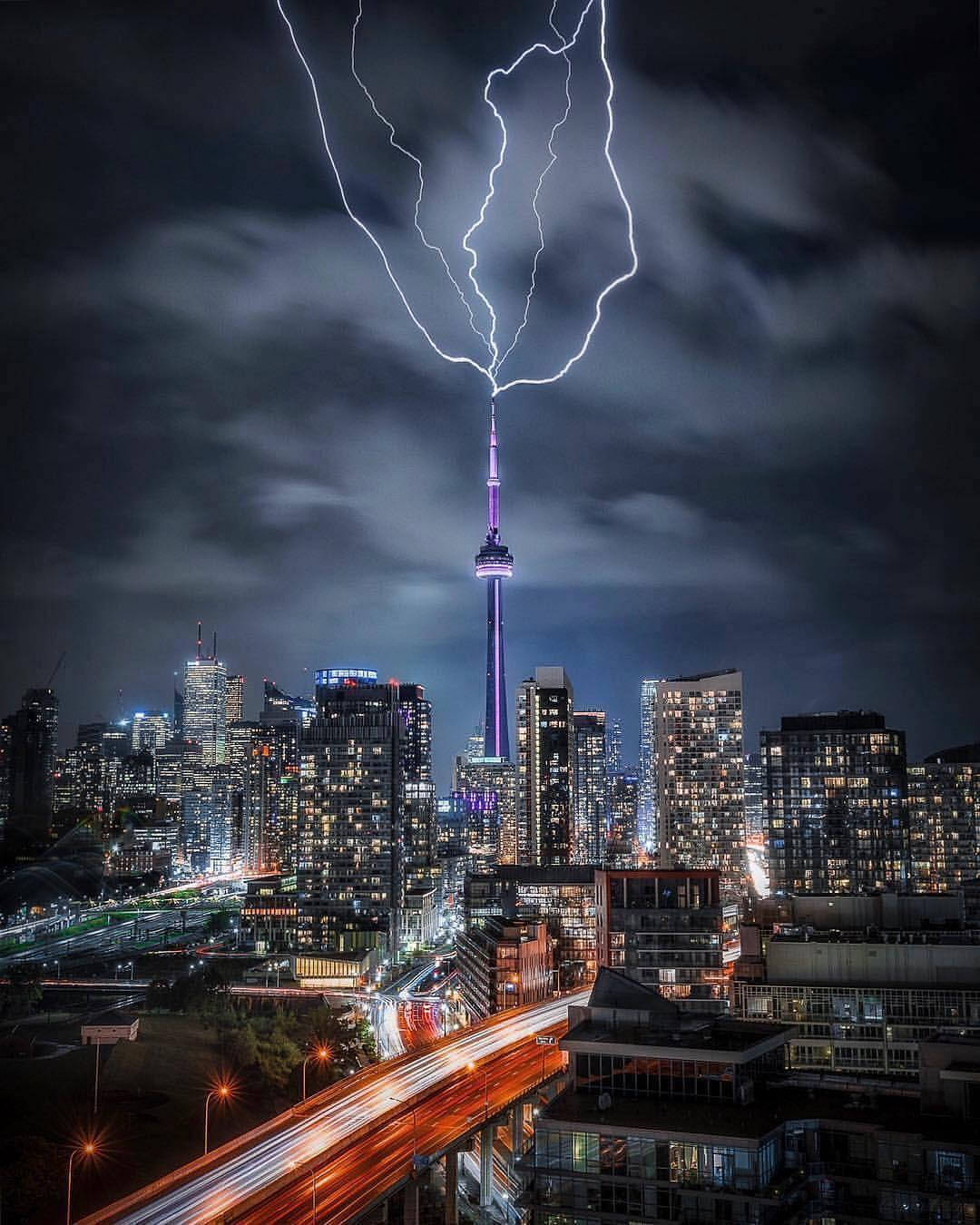 閃電擊中CN塔，下方是夜晚發光的城市景觀。