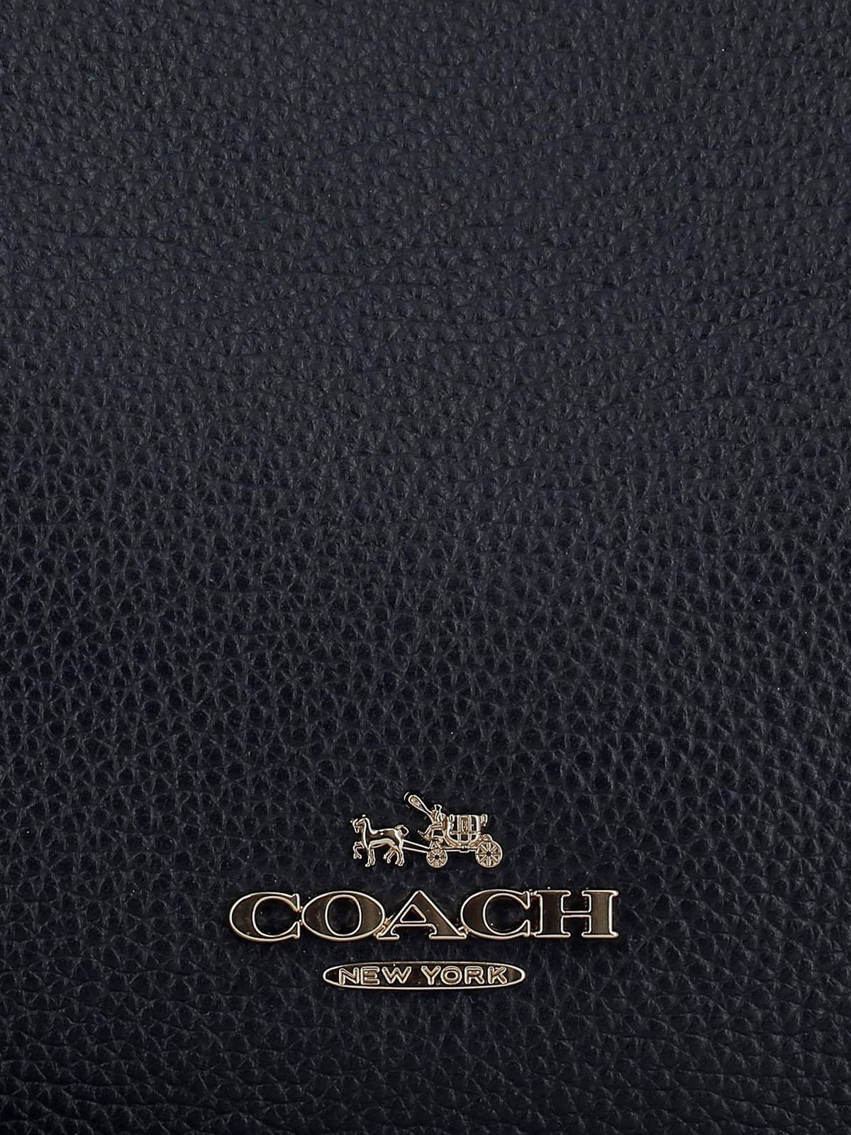 黑色皮革Coach手袋，帶有金色標誌和馬車徽章。