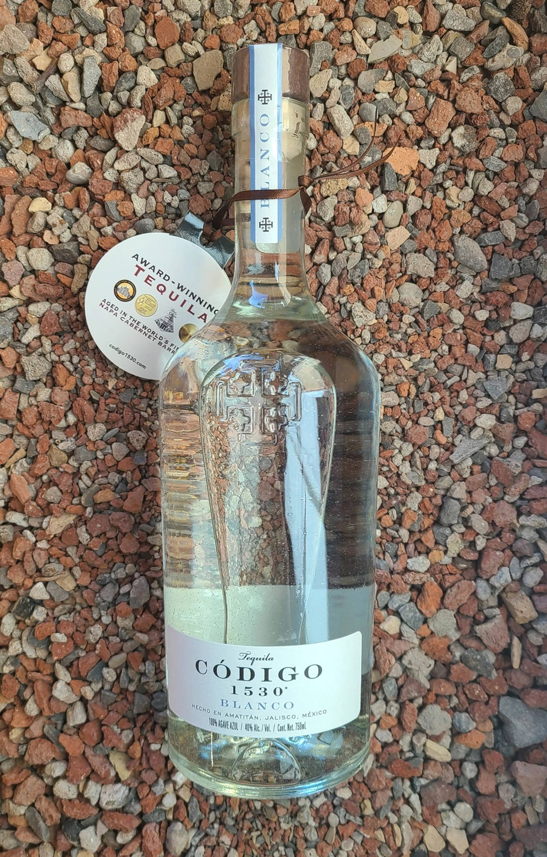 獲獎龍舌蘭酒瓶在礫石背景上