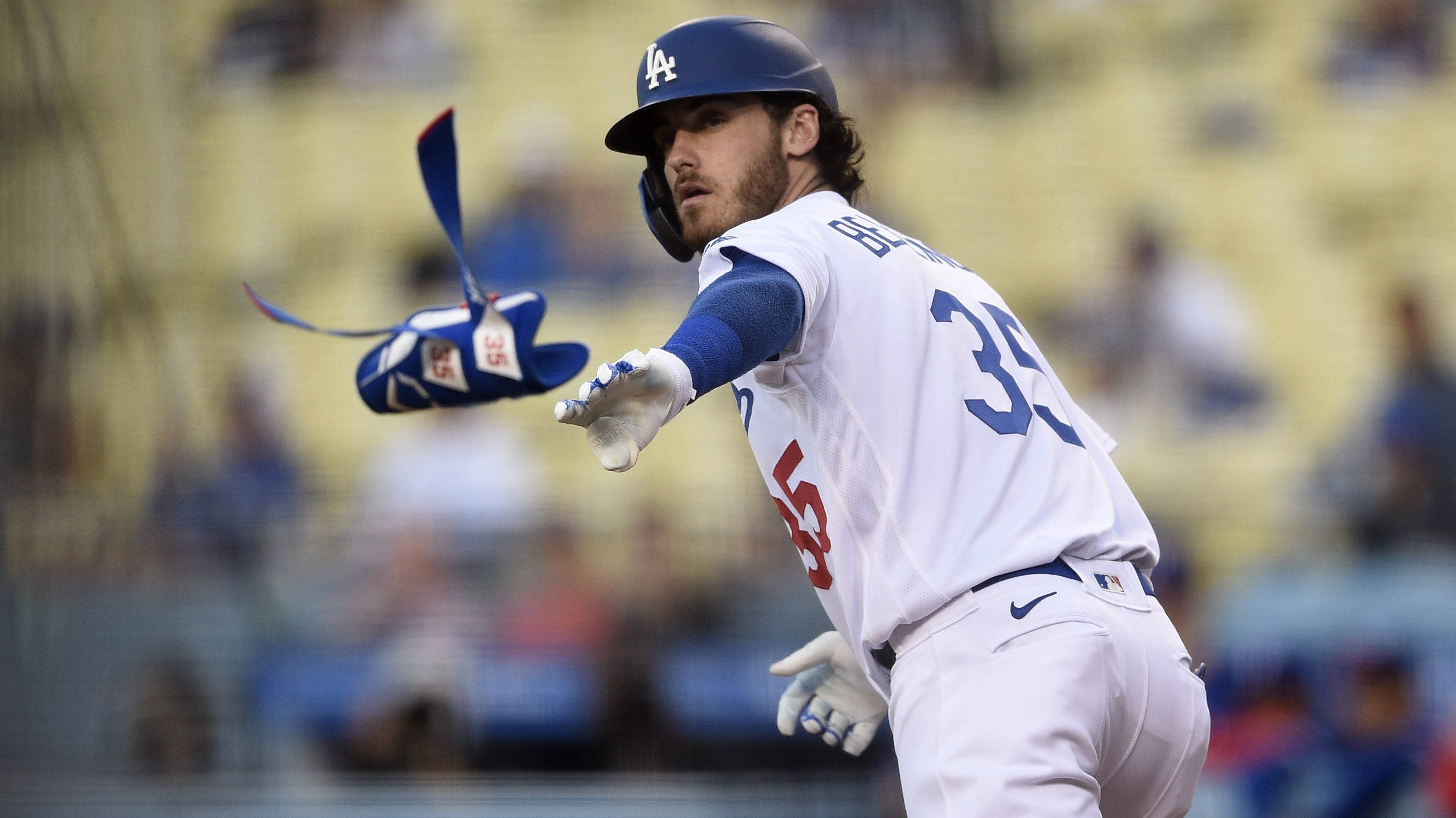 Cody Bellinger 專注攝影 壁紙 — 身穿道奇隊球衣的棒球手在日間比賽中專注地揮棒。
