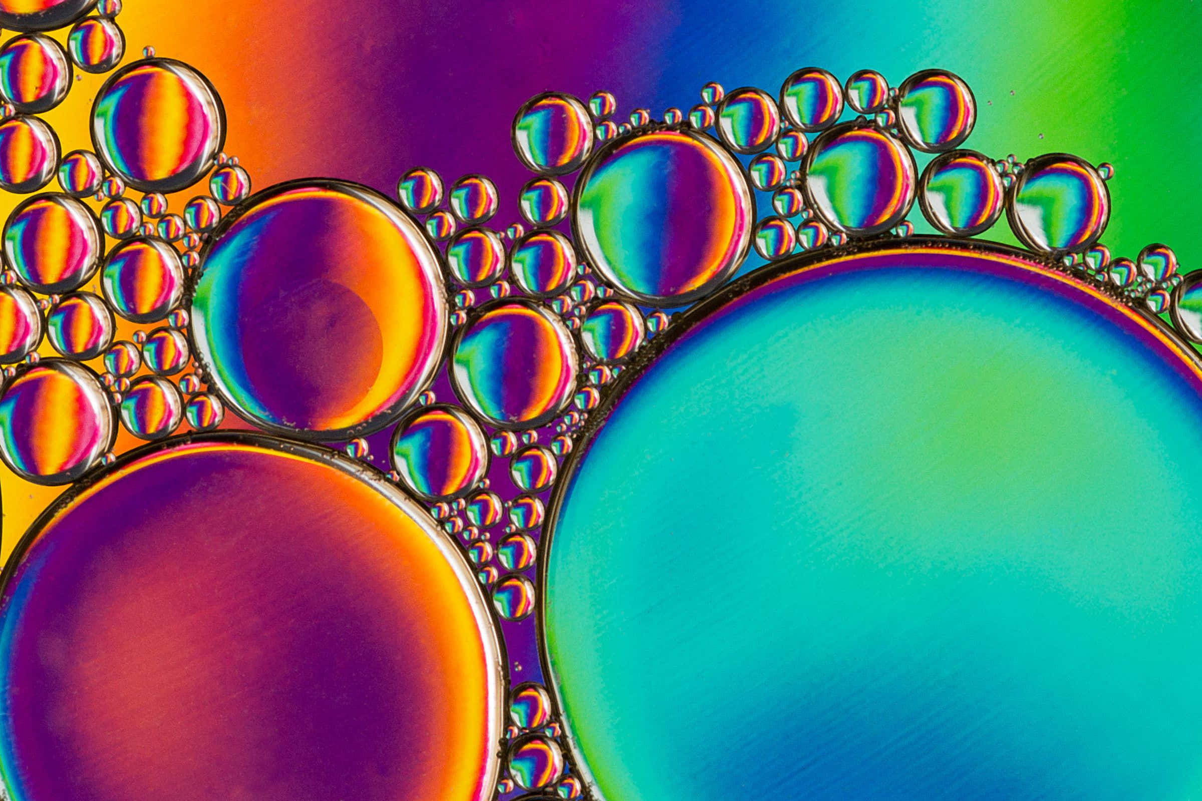以Colorful釋放創意 壁紙 — 充滿活力的彩虹色肥皂泡聚集在一起，形成迷人的微距圖案。