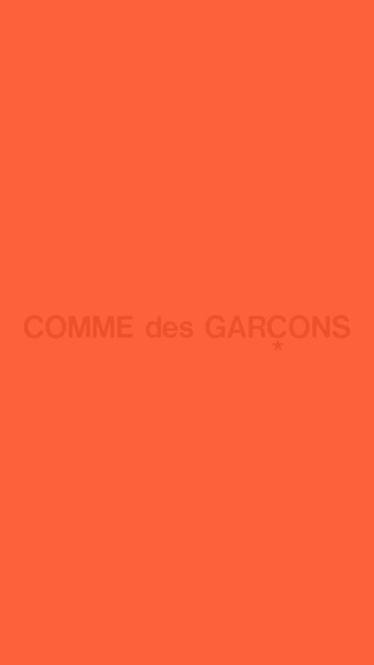 橙色背景，中央有模糊的COMME des GARÇONS文字。