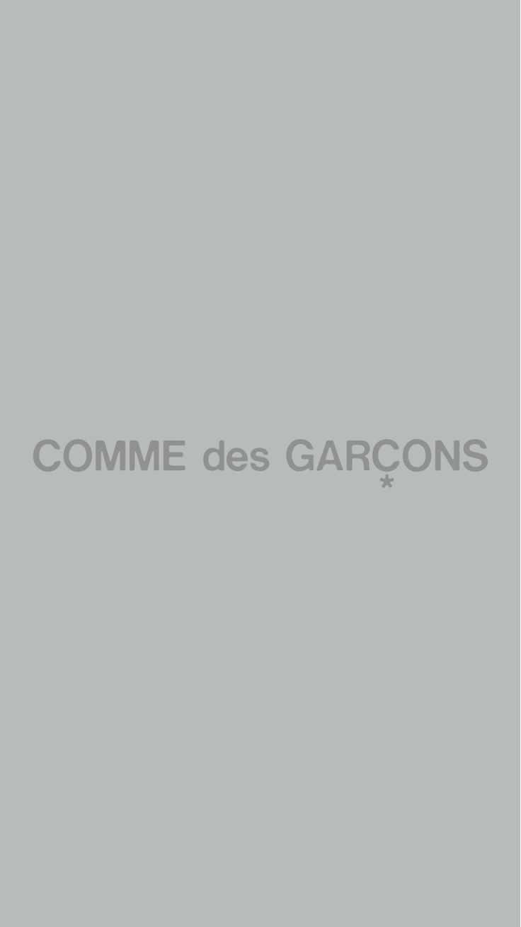 灰色背景，中央放置 COMME des GARCONS 標誌，柔和灰色。