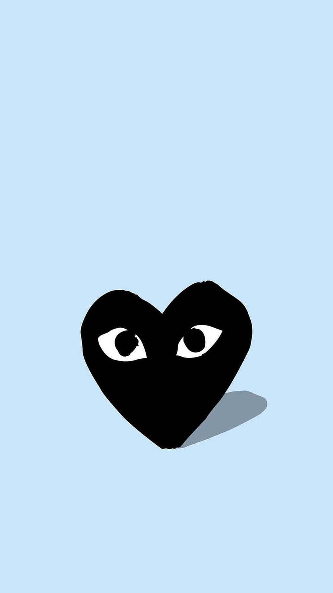 Comme Des Garçons黑心藍色背景 壁紙 — 一個極簡風格的黑色心形，帶有白色眼睛，凝視著柔和的藍色背景，投下微妙的陰影。
