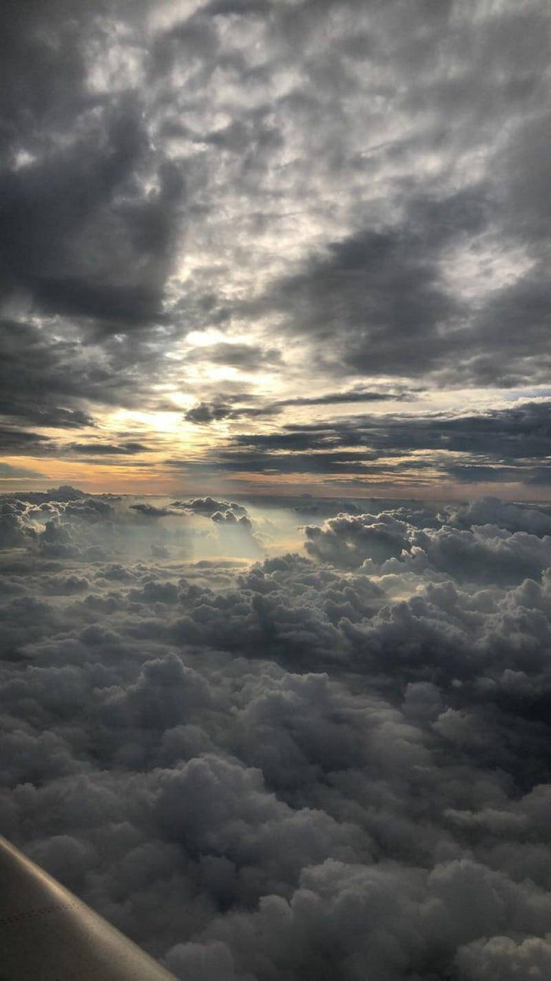 日落時分的雲層鳥瞰圖，可見飛機機翼