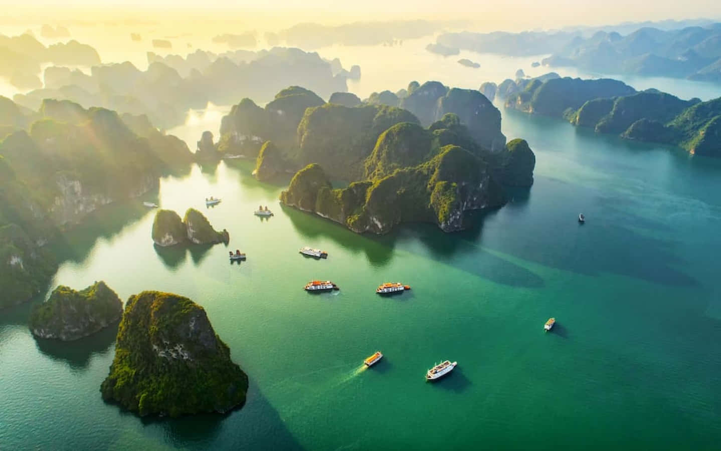 喀斯特島嶼在翠綠色海上與日出小船