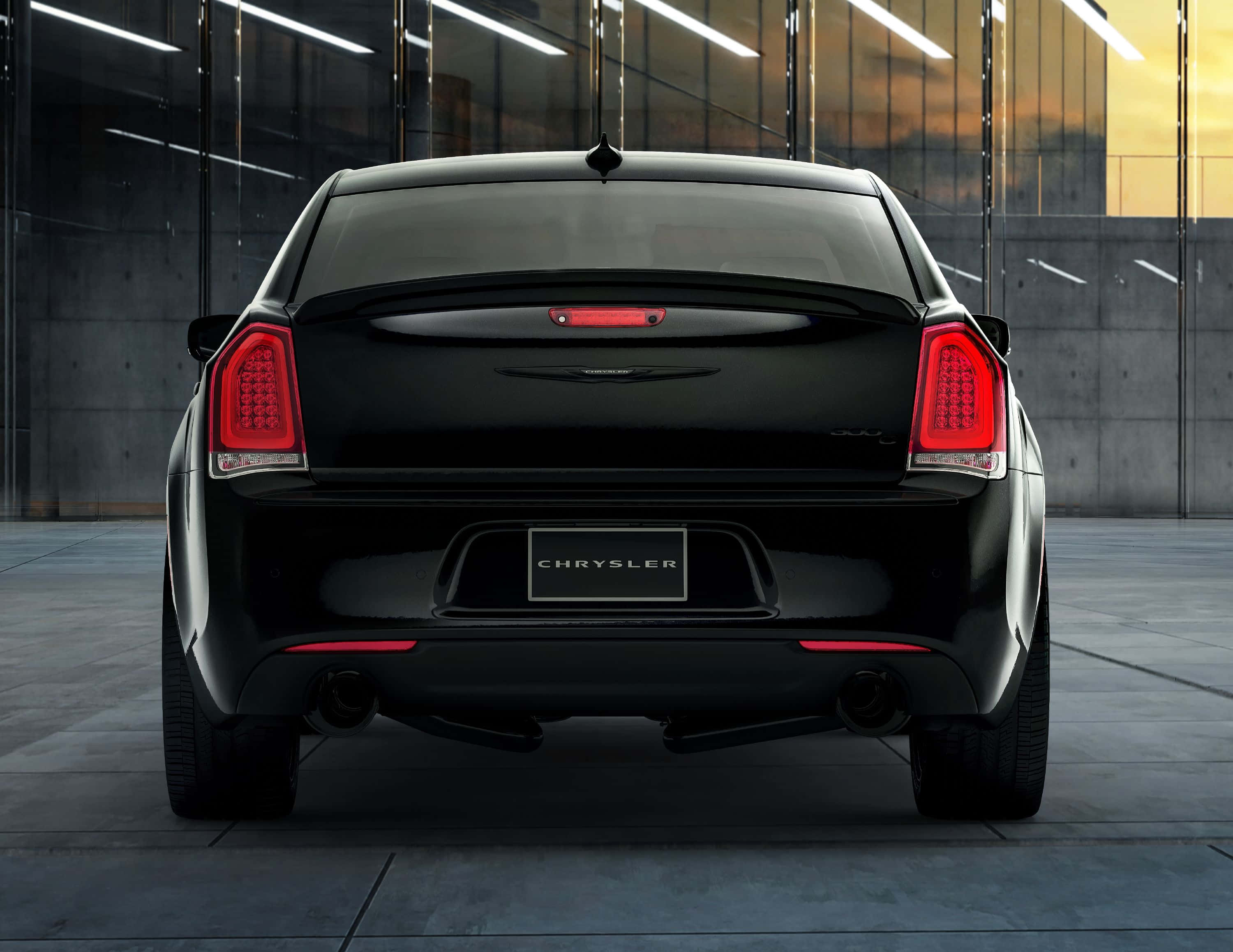 Chrysler 300 桌布 壁紙 — 從後方觀看一輛時尚的黑色克萊斯勒轎車，位於現代車庫中，夕陽光線透過玻璃牆照射進來。