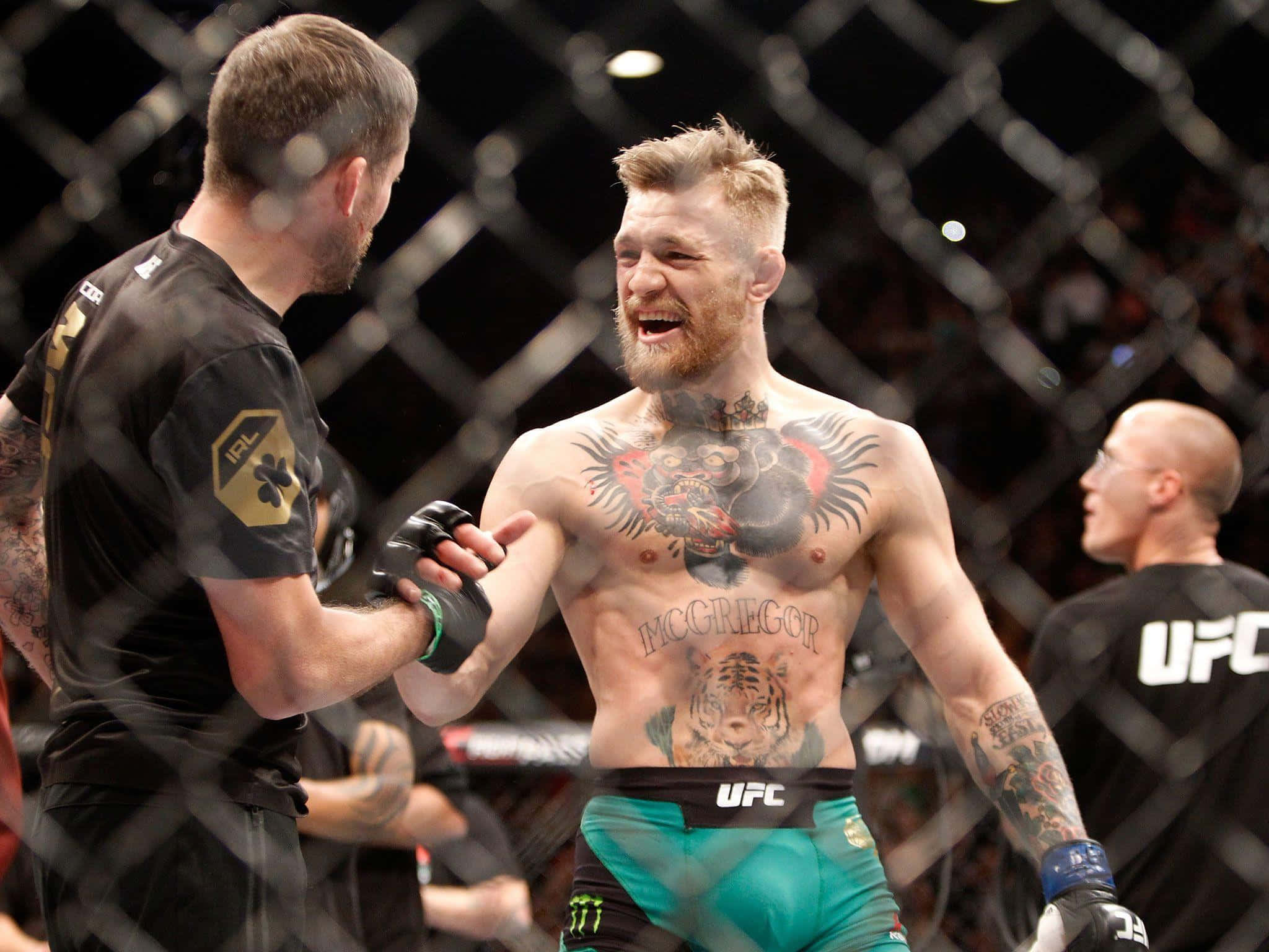 康納·麥格雷戈 桌布 壁紙 — Conor McGregor 在UFC八角籠中慶祝勝利，露出勝利的笑容和紋身上身。