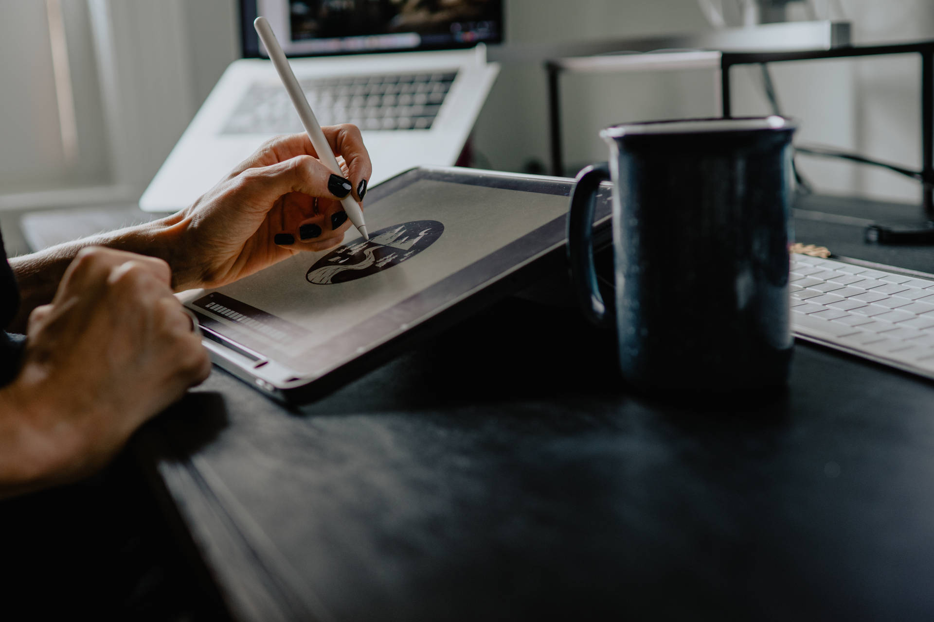 當代數位藝術 - 抽象色彩 壁紙 — 一個塗黑色指甲油的人正在時尚的桌子上，在筆記本電腦和深色馬克杯旁邊的繪圖板上畫畫。