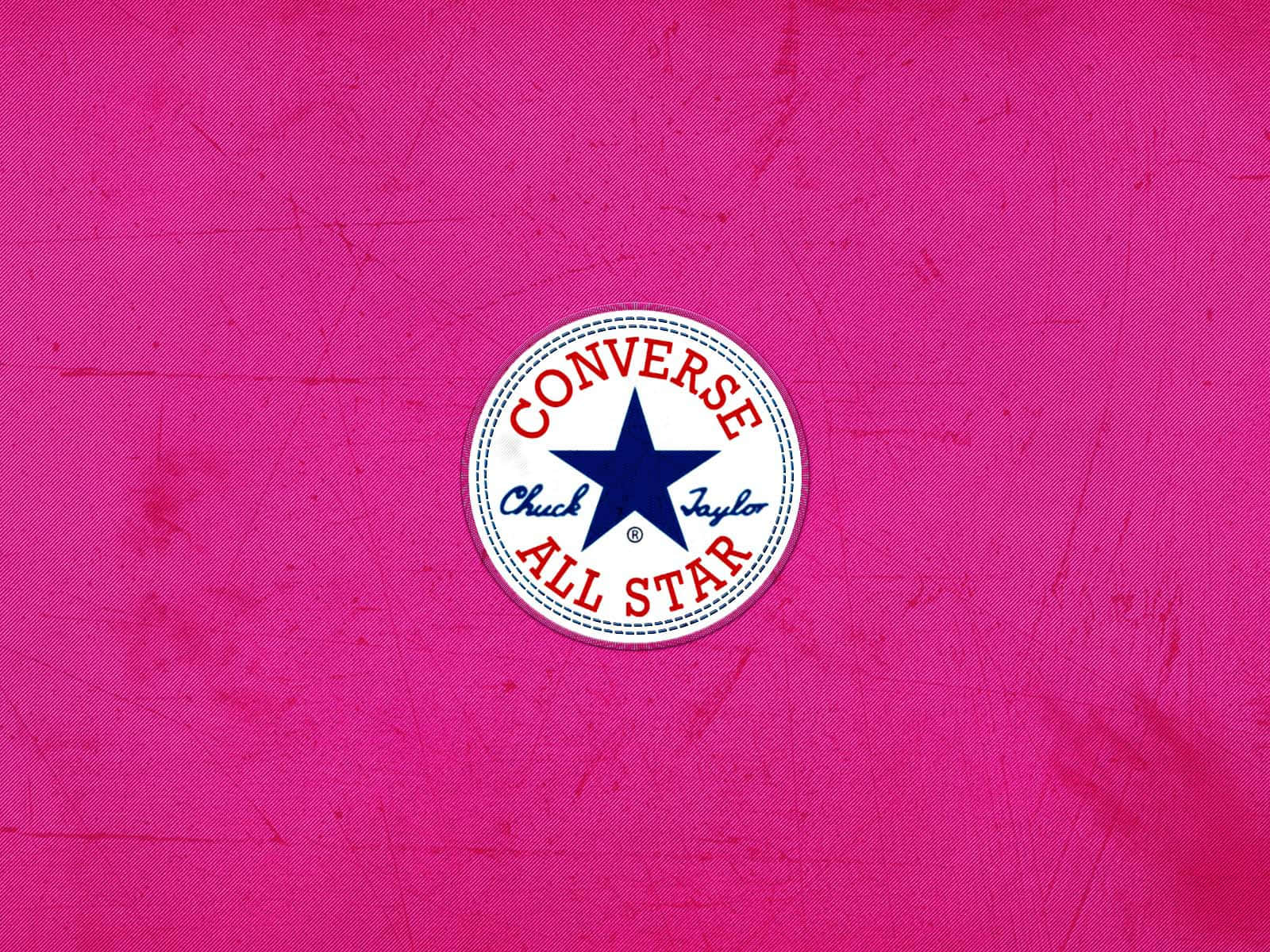 粉紅色布料上帶有刮痕的 Converse All Star 標誌