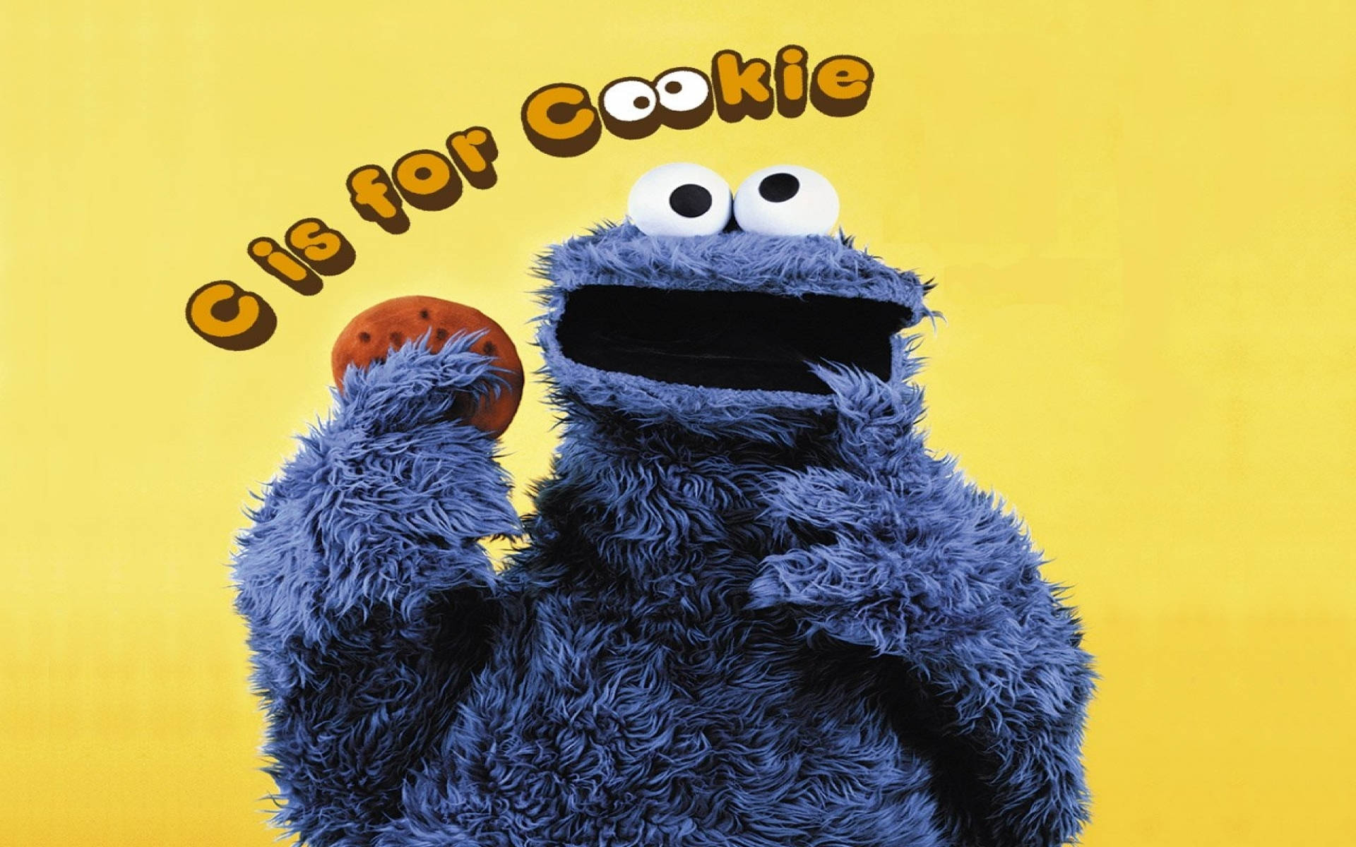 餅乾怪獸拿著一塊朱古力曲奇，上面有「C is for Cookie」文字。