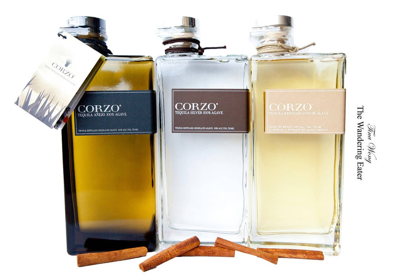白色背景上三瓶Corzo龍舌蘭酒瓶搭配肉桂棒。