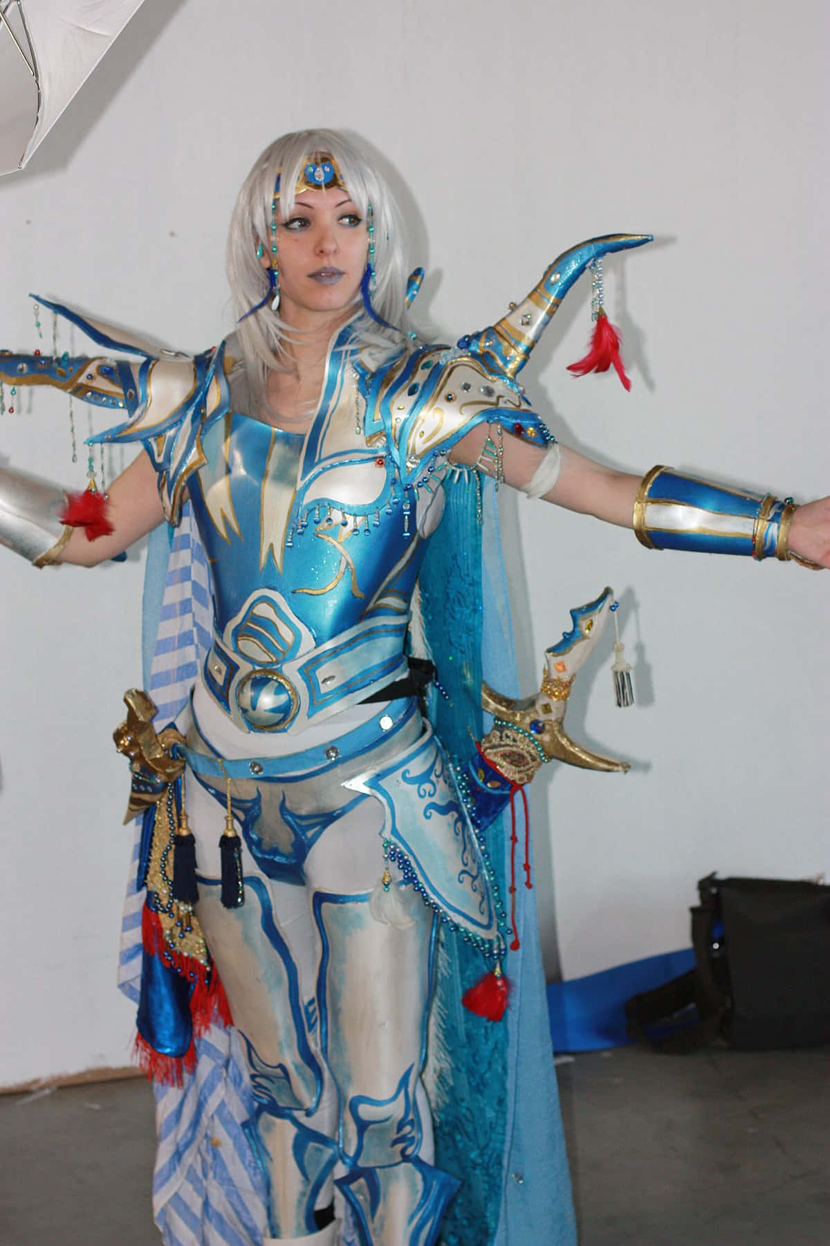  壁紙 — 一位穿著精緻藍銀色盔甲、配有紅色流蘇的cosplayer在室內擺出動態姿勢。