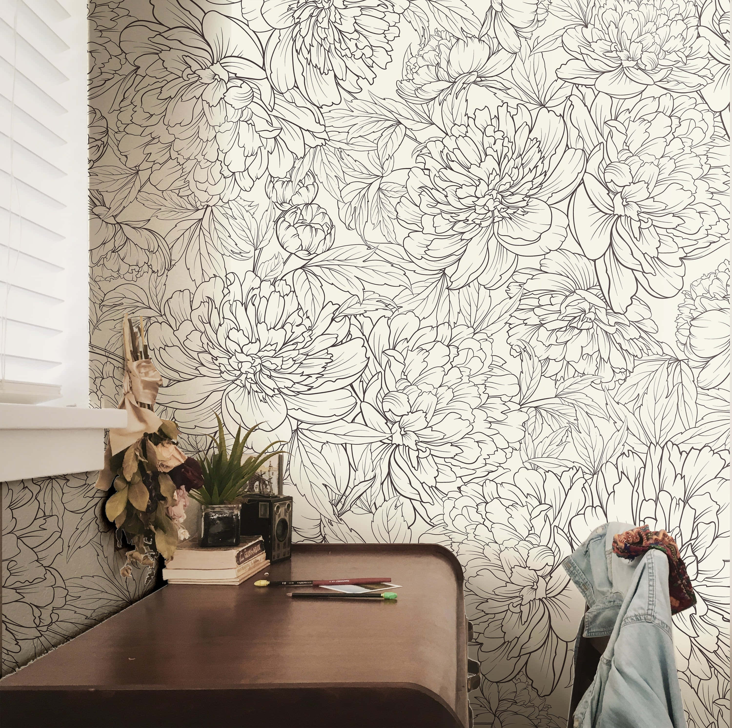 Home Decor 桌布 壁紙 — 一個舒適的角落，木製書桌靠著牆，牆上覆蓋著複雜的黑色線條藝術牡丹壁紙。