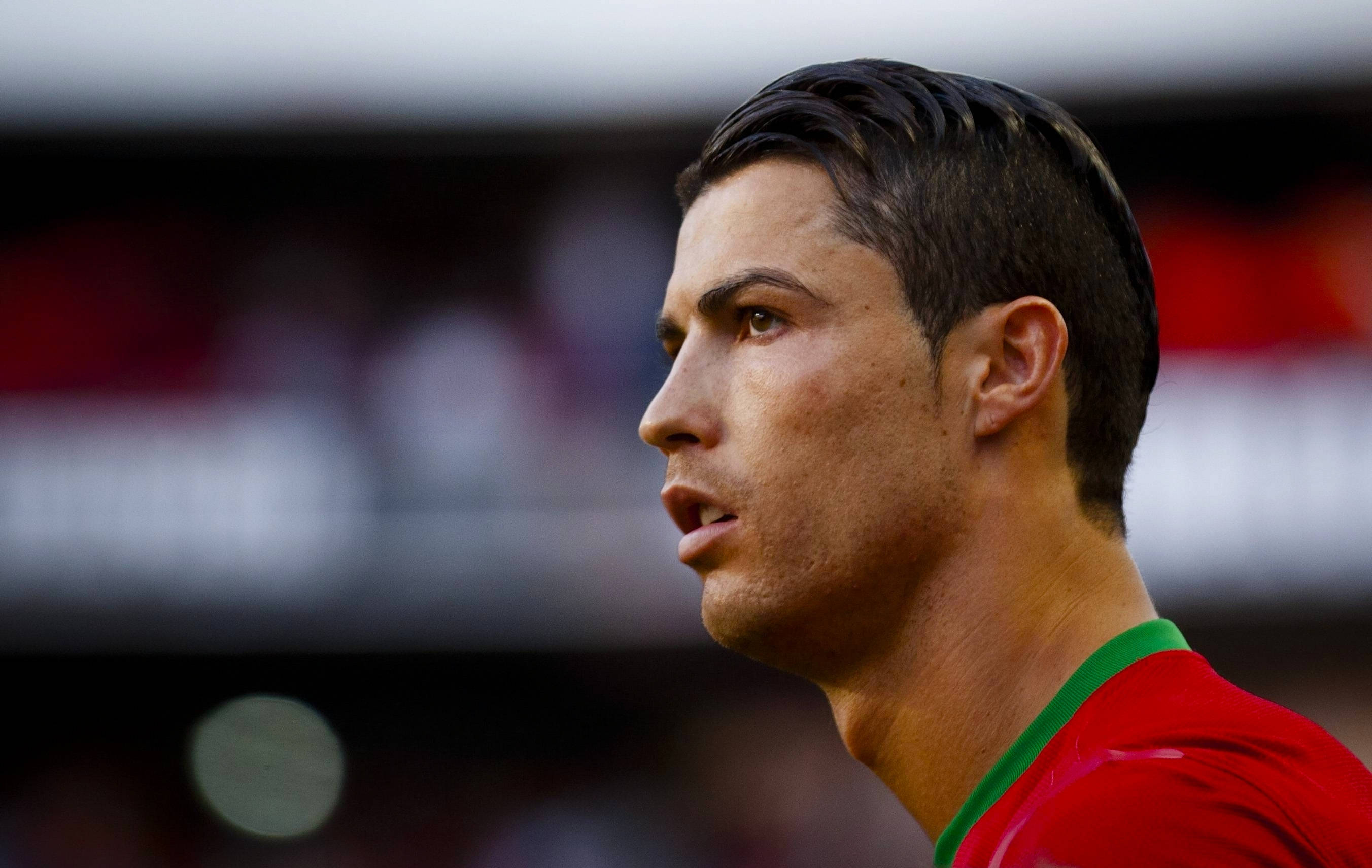 CR7 側面剪影 壁紙 — 基斯坦奴朗拿度身穿紅色葡萄牙球衣，在比賽中專注的近距離側面照。