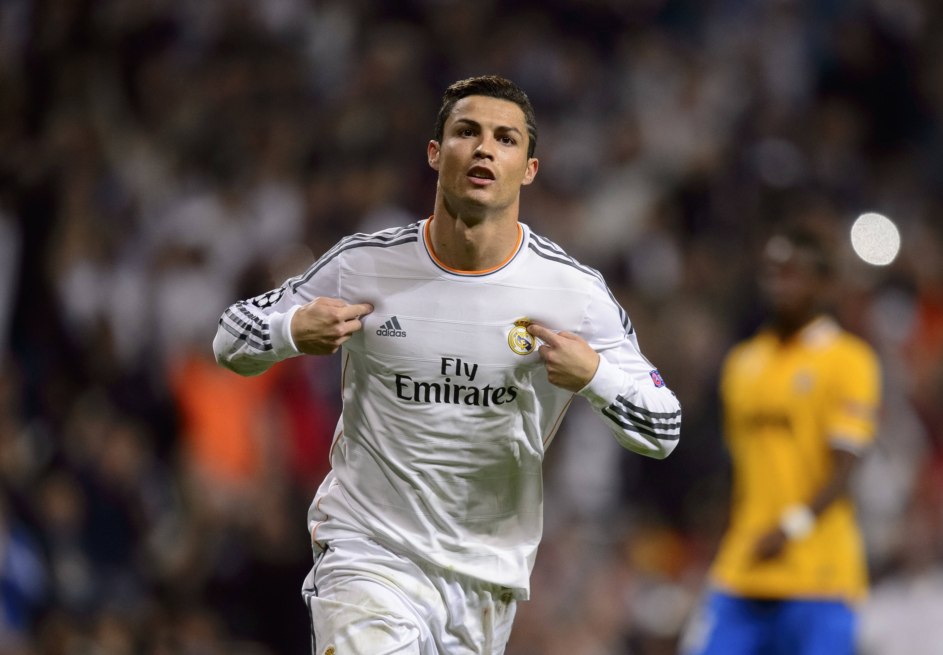 CR7 克里斯蒂亞諾·羅納度 壁紙 — 基斯坦奴朗拿度身穿白色皇家馬德里球衣，在夜間足球比賽中於球場燈光下雙手放在胸前慶祝。