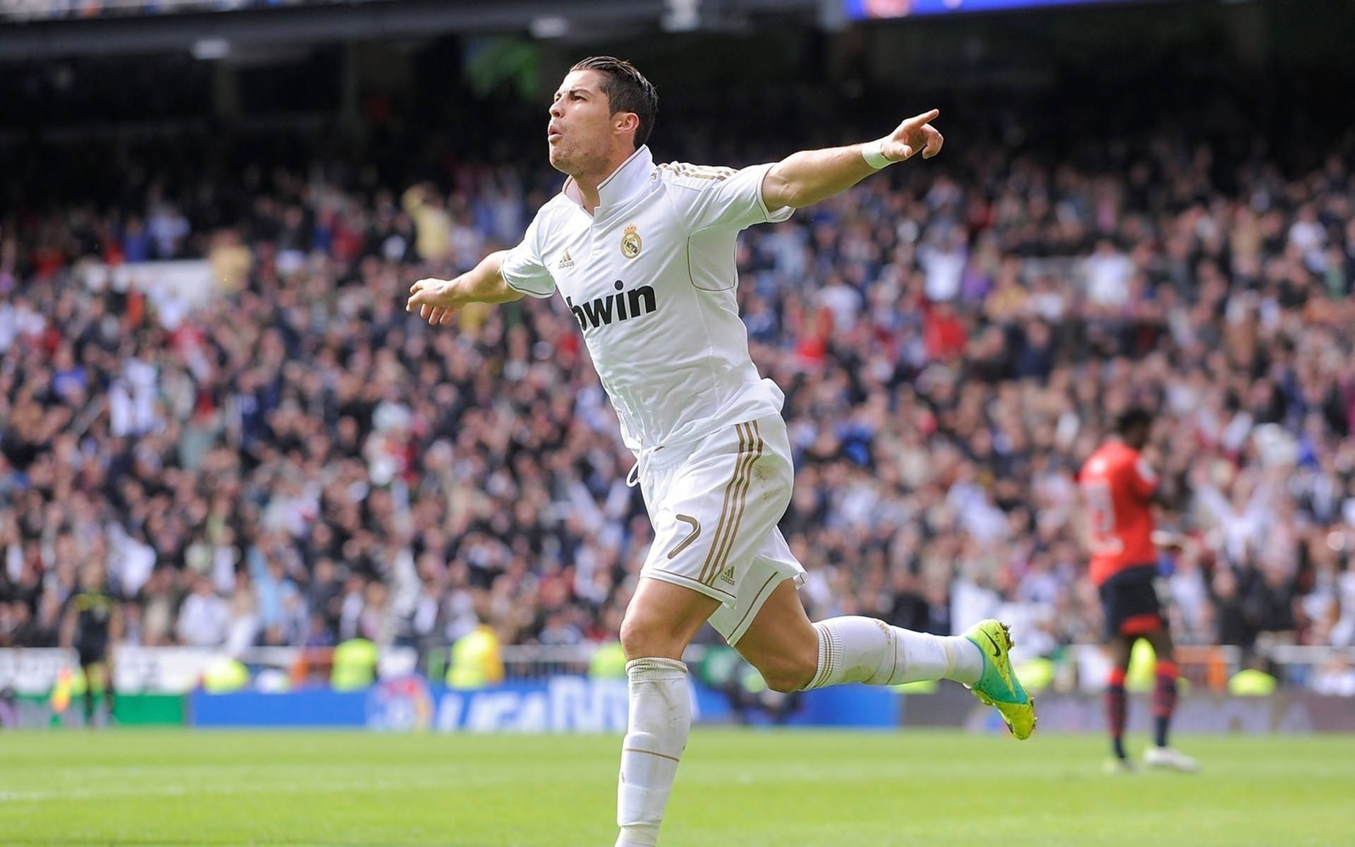 CR7 在球場奔跑 壁紙 — 一名身穿白色皇家馬德里球衣的足球運動員在陽光明媚的球場上張開雙臂慶祝入球。