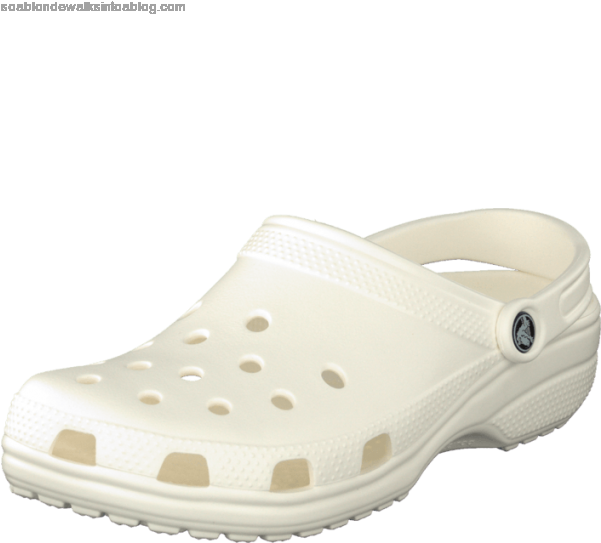 白色經典Croc涼鞋 壁紙 — 一隻白色木屐涼鞋，帶有穿孔和標誌，背景為黑色。
