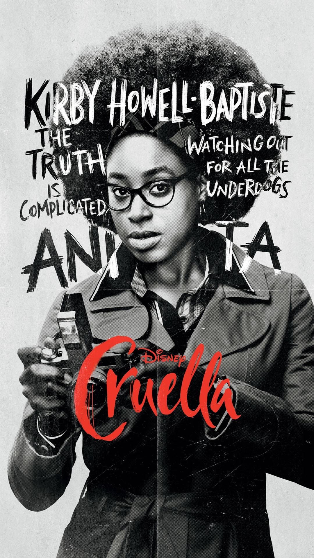 女演員 Kirby Howell-Baptiste 在迪士尼《黑白魔后》中飾演 Anita，手持相機。
