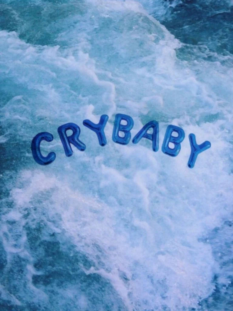 iPad pro cute 桌布 壁紙 — crybaby 這個詞漂浮在洶湧的藍色海浪中，伴隨著泡沫狀的白色泡沫。