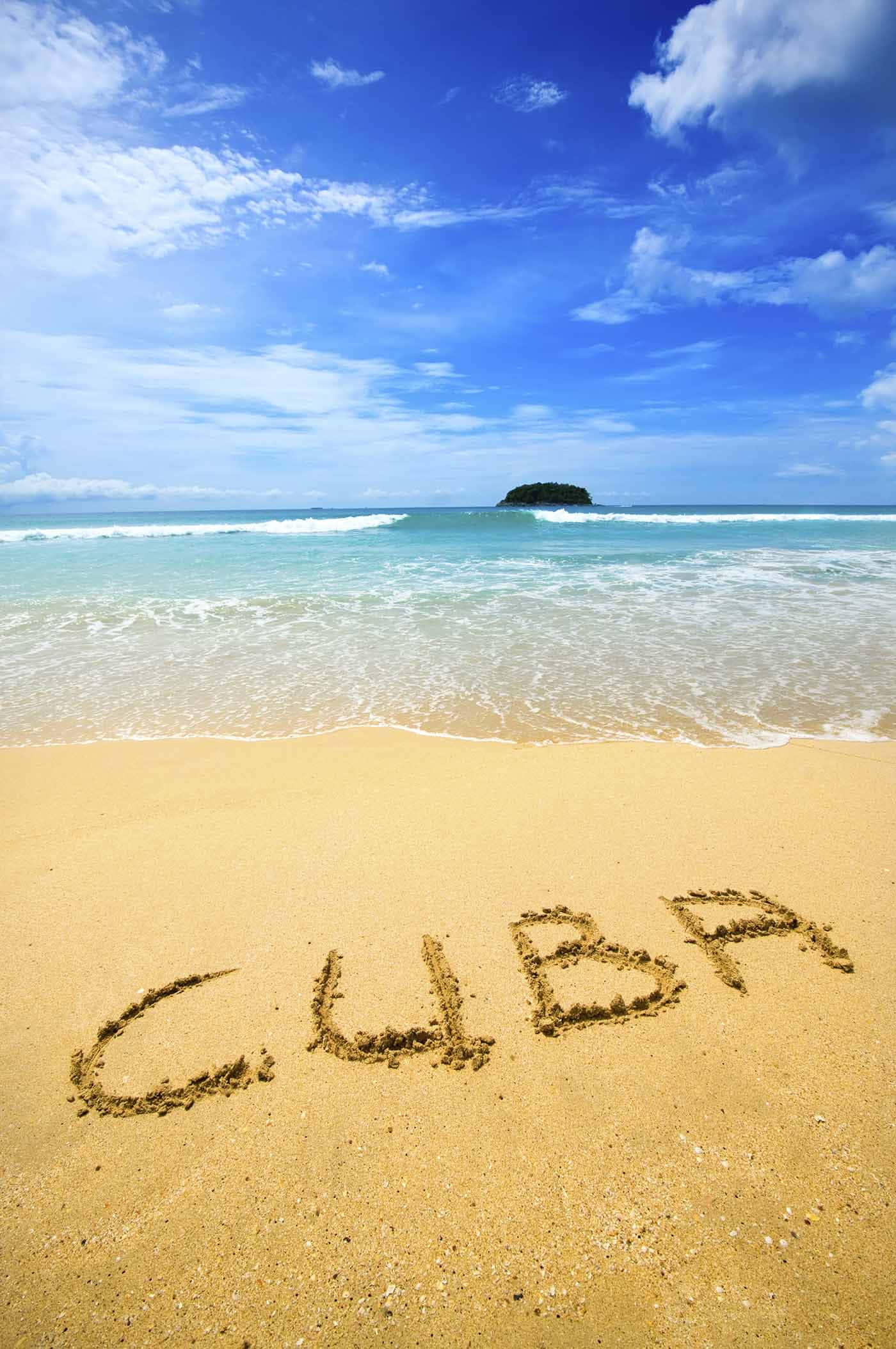 Cuba 桌布 壁紙 — 「CUBA」呢個字寫喺一個陽光海灘嘅沙上，有藍綠色嘅海浪同遠處嘅島嶼，天空係明亮嘅藍色。