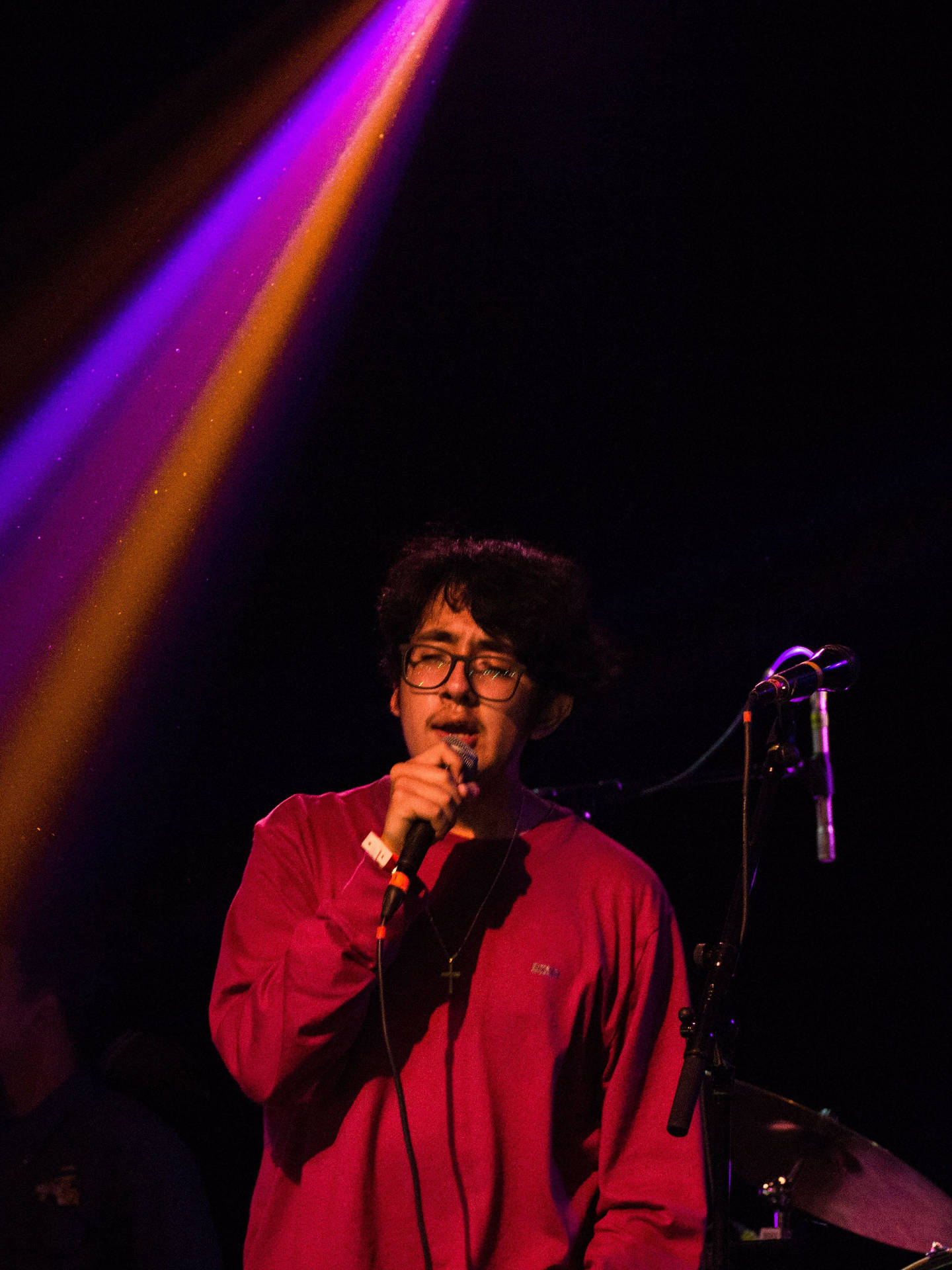 紅衫歌手在彩色舞台燈光下表演。