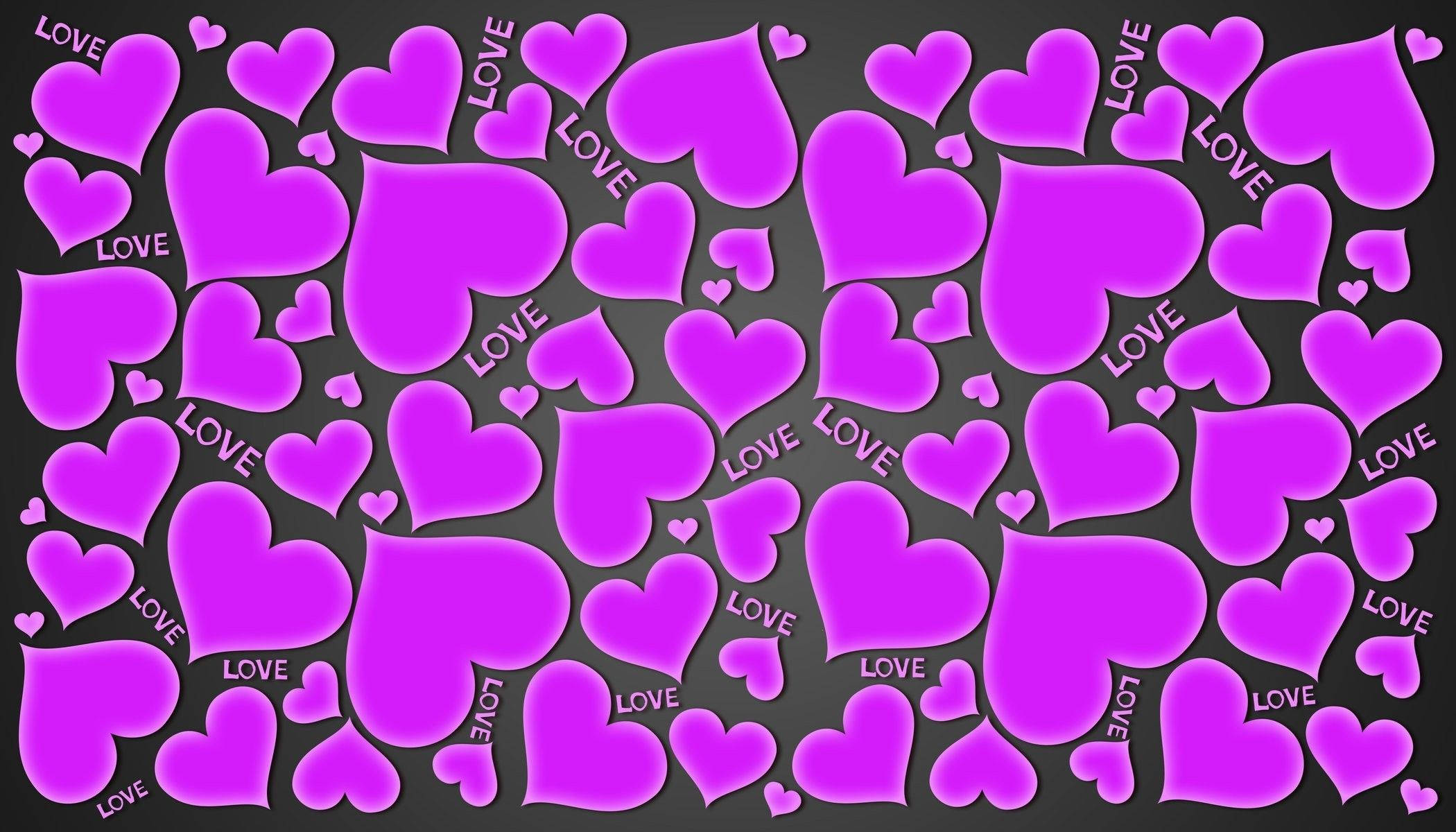大小不一紫色心形 LOVE 壁紙 — 各種大小的鮮豔粉紅色心形漂浮在深灰色背景上，許多心形上刻有love字樣。
