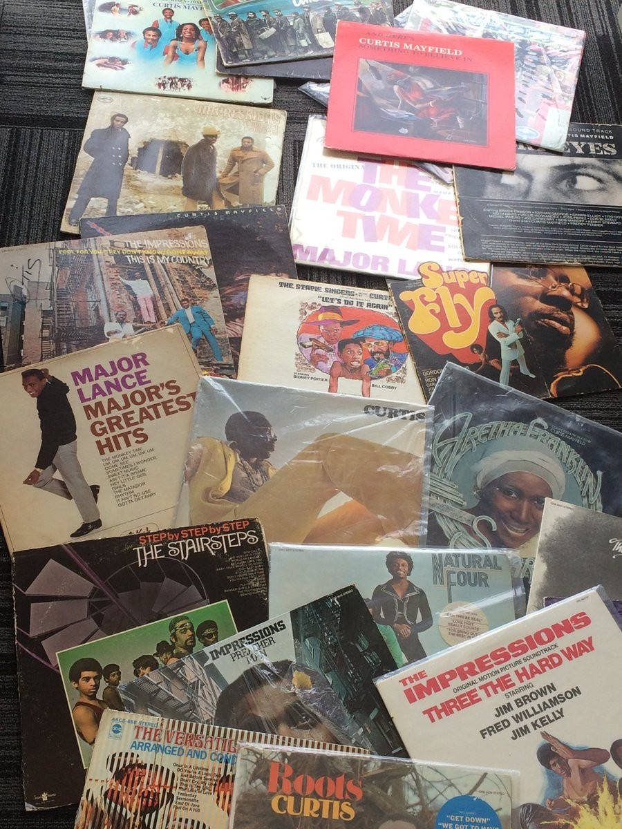 Curtis Mayfield 和 The Impressions 最佳金曲專輯 壁紙 — 一張充滿活力的拼貼畫，展示散落在深色紋理表面上的復古靈魂樂和放克黑膠唱片專輯封面。
