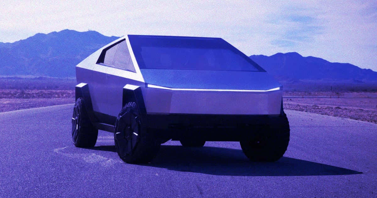 特斯拉 Cybertruck — 精緻、時尚、創新 壁紙 — 一架未來感十足的銀色Tesla Cybertruck停泊在沙漠公路上，背景是藍天白雲下的山脈。