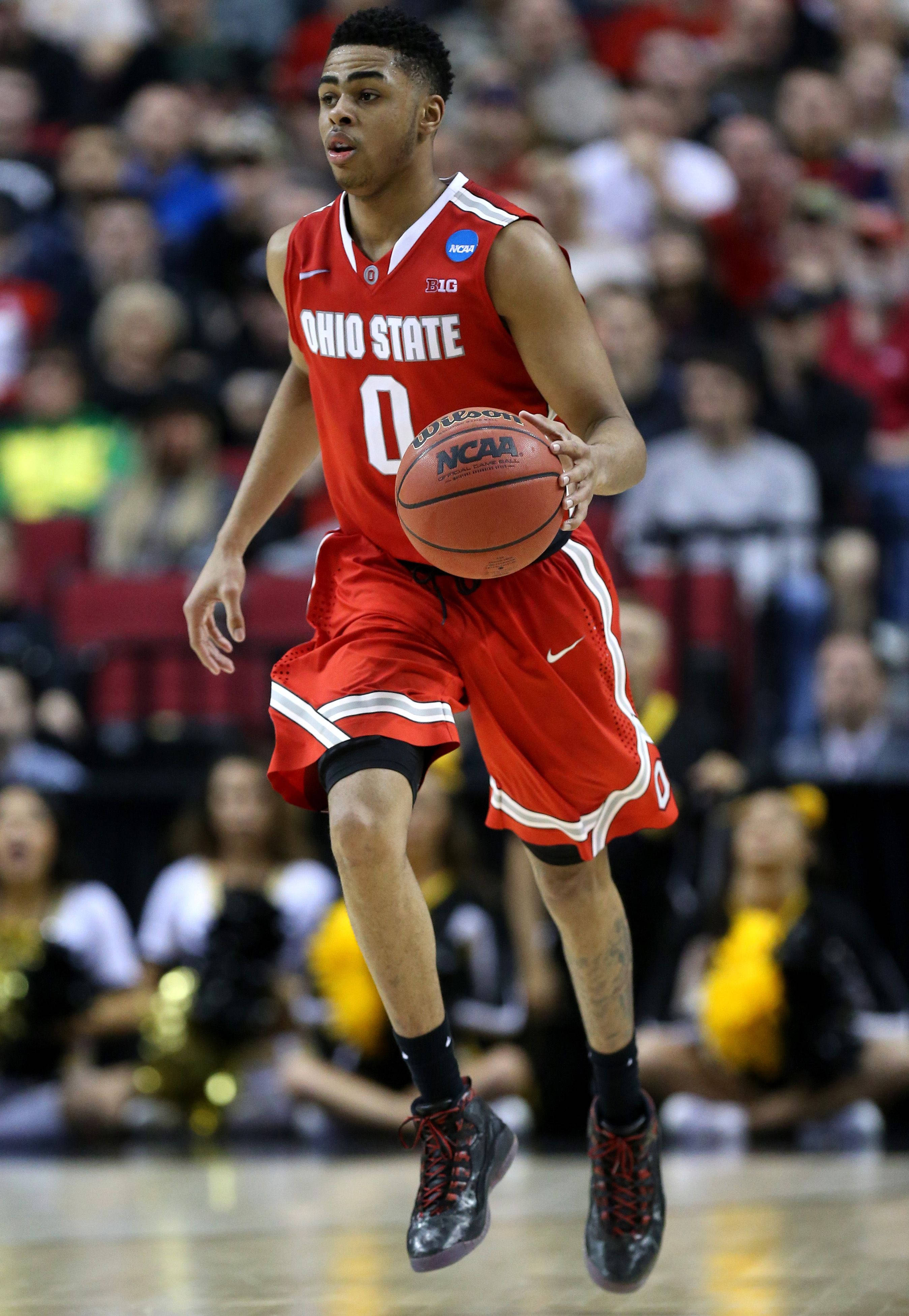 D'Angelo Russell 俄亥俄州立大學 壁紙 — 一名身穿紅色俄亥俄州立大學球衣的籃球運動員在NCAA比賽中跳起運球，背景是模糊的人群。