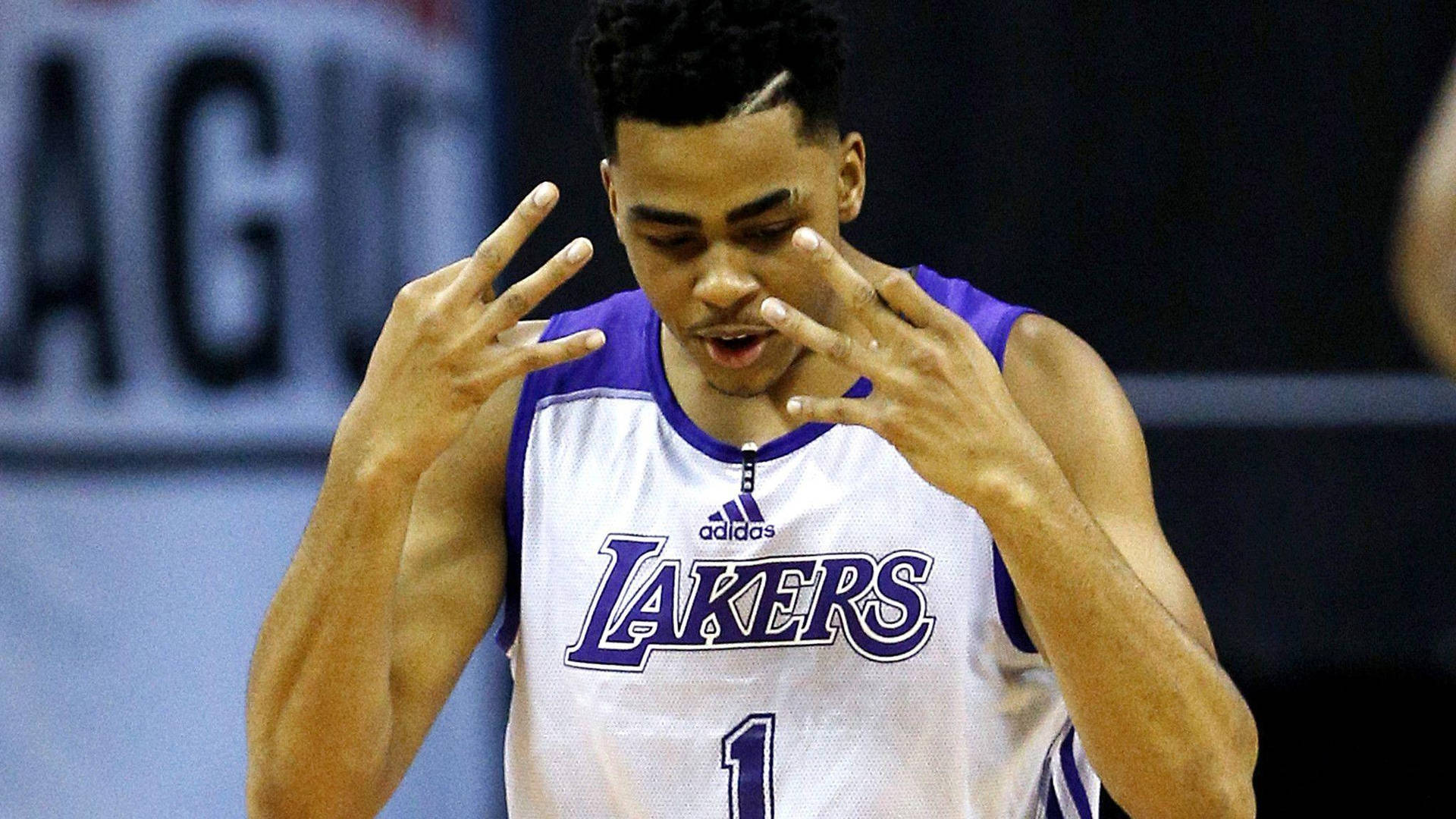 D'Angelo Russell NBA 夏季聯賽 壁紙 — 一位專注的籃球運動員身穿湖人隊球衣，在激烈的比賽中雙手做出手勢。