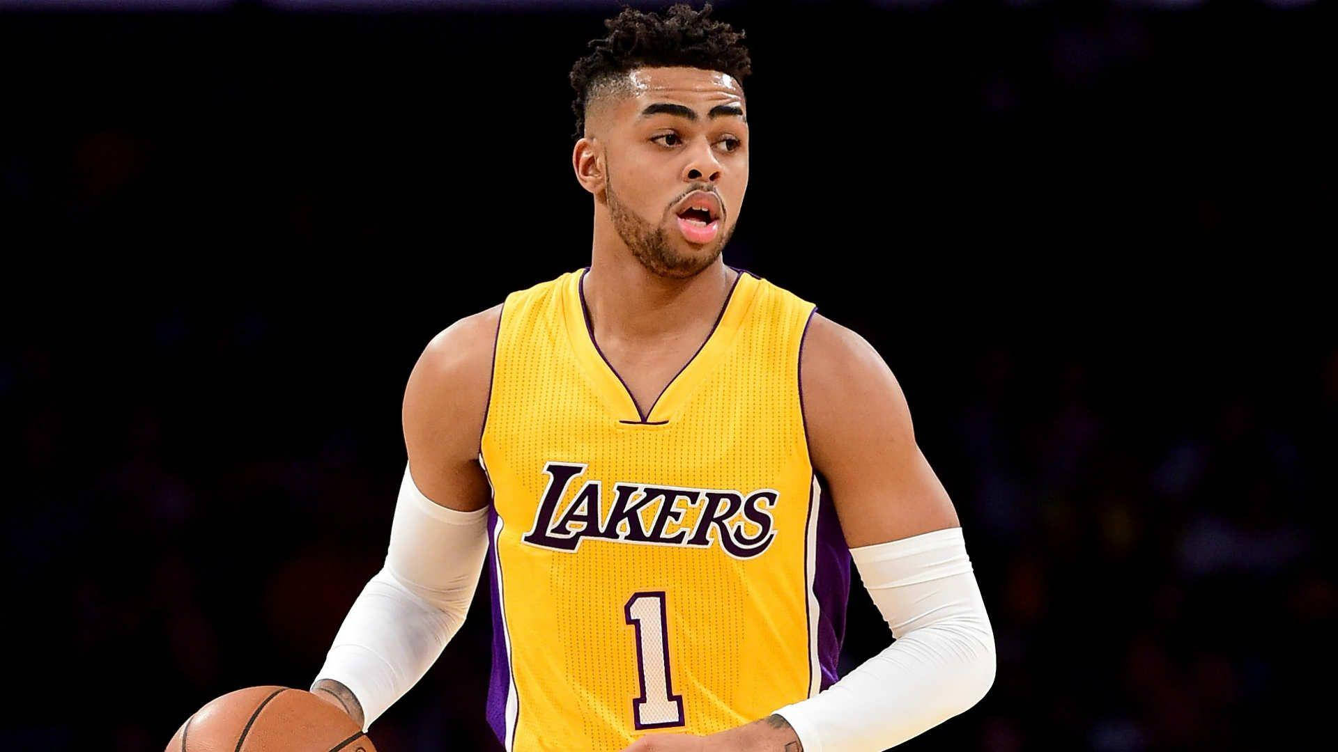 D'Angelo Russell 高畫質黑底 壁紙 — 一位專注的籃球運動員，身穿黃色湖人隊球衣，背號一號，在深色背景下運球。