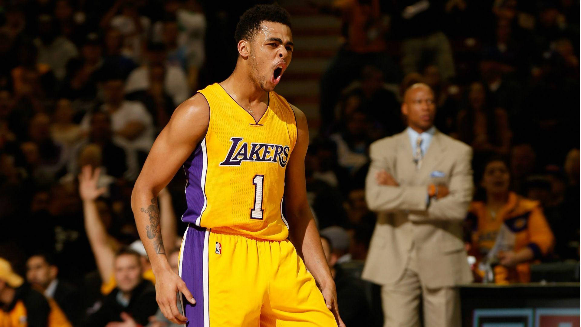 D'Angelo Russell 洛杉磯湖人隊 壁紙 — 一名身穿黃色湖人隊球衣、背號1號的籃球運動員在場館燈光下比賽時戲劇性地打哈欠。