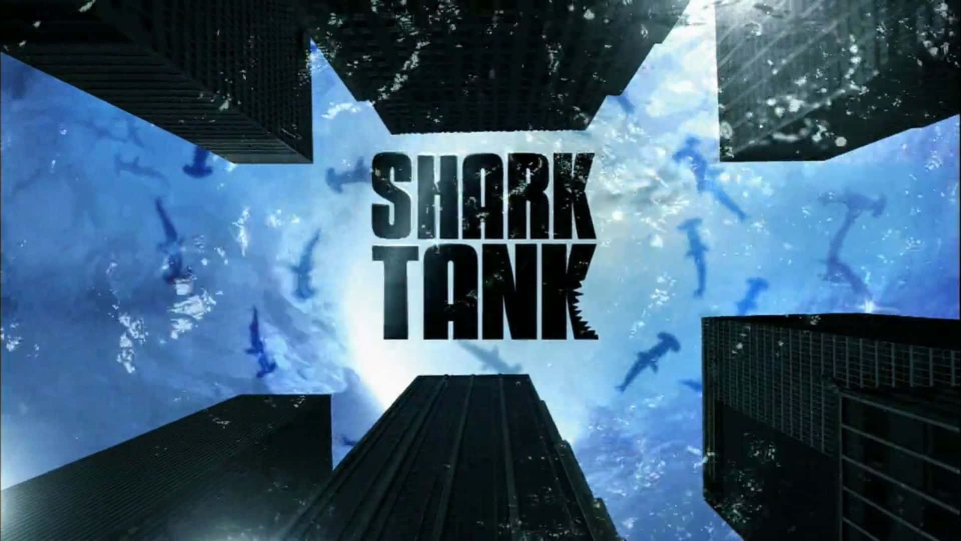  壁紙 — 大膽的黑色「SHARK TANK」文字主導了一個超現實的水下城市景觀，其中有摩天大樓和游泳的鯊魚。
