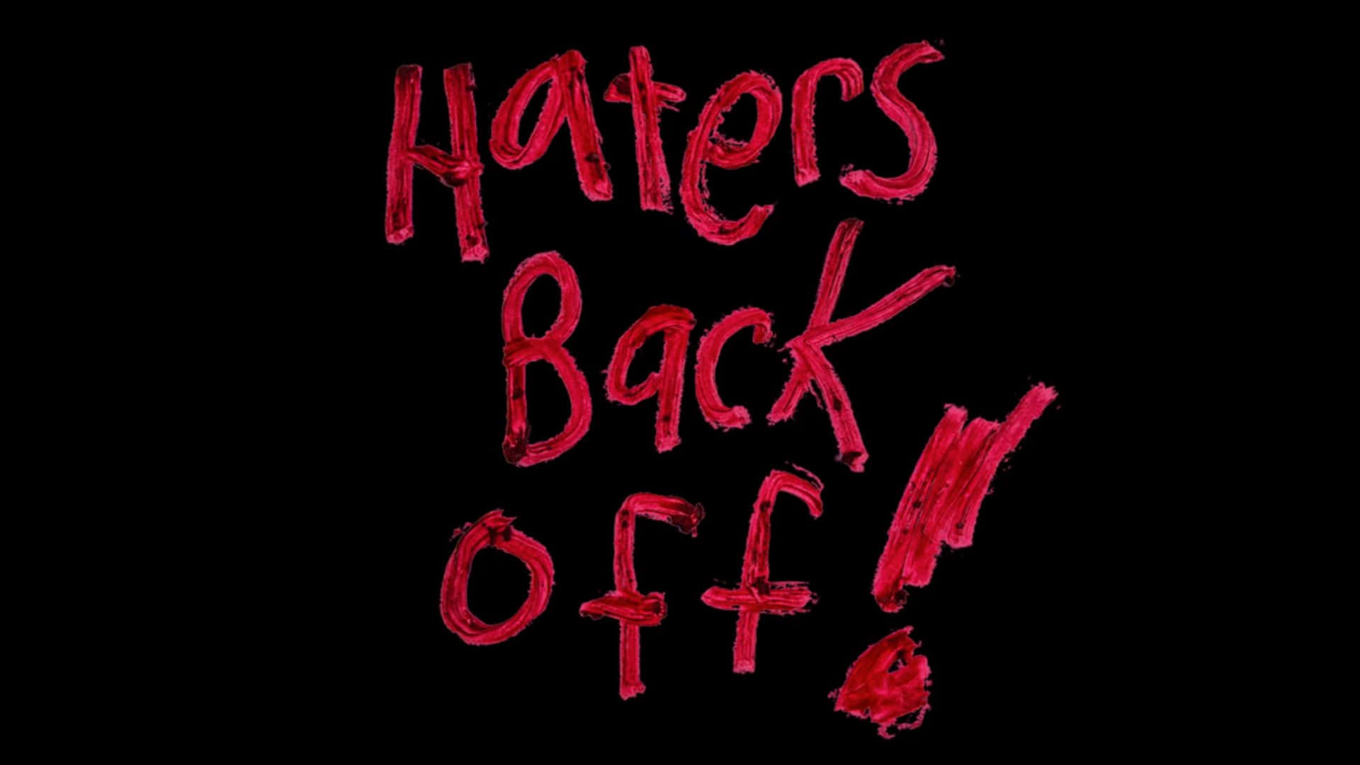  壁紙 — 大膽的紅色塗鴉風格文字在純黑背景上寫著「Haters Back Off!」。