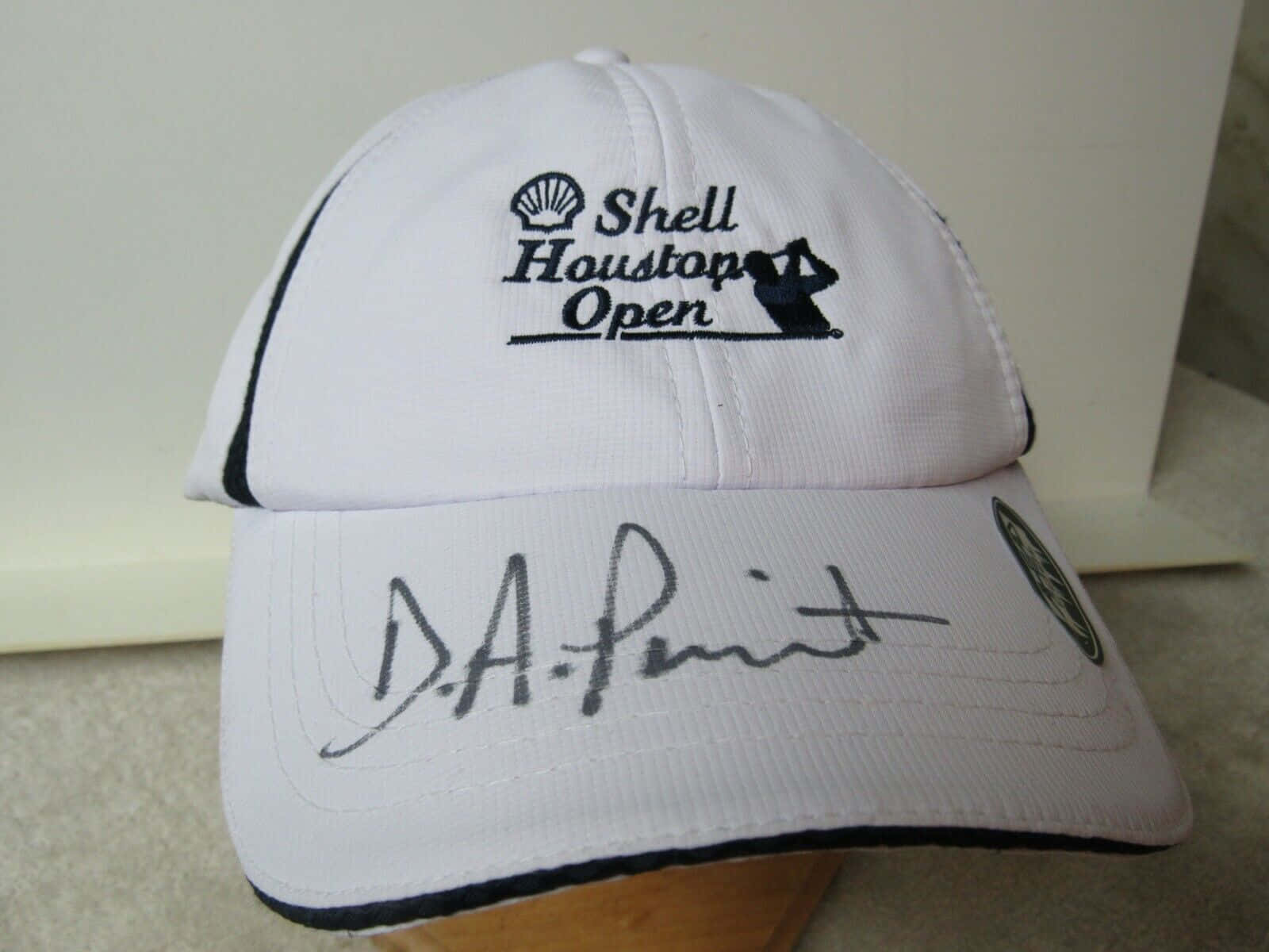 白色高爾夫球帽，帶有Shell Houston Open標誌和D A Pont簽名。