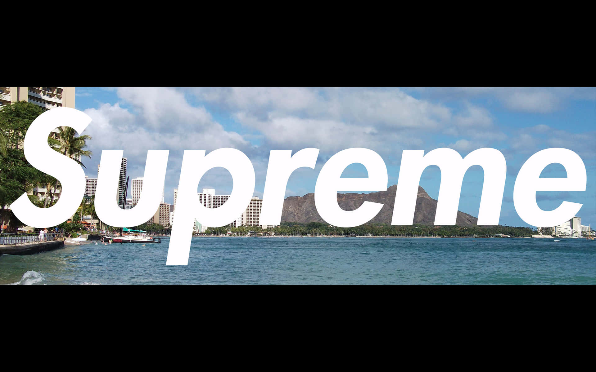 海岸城市，海洋、棕櫚樹和山脈在一個大型白色 Supreme 標誌後面。