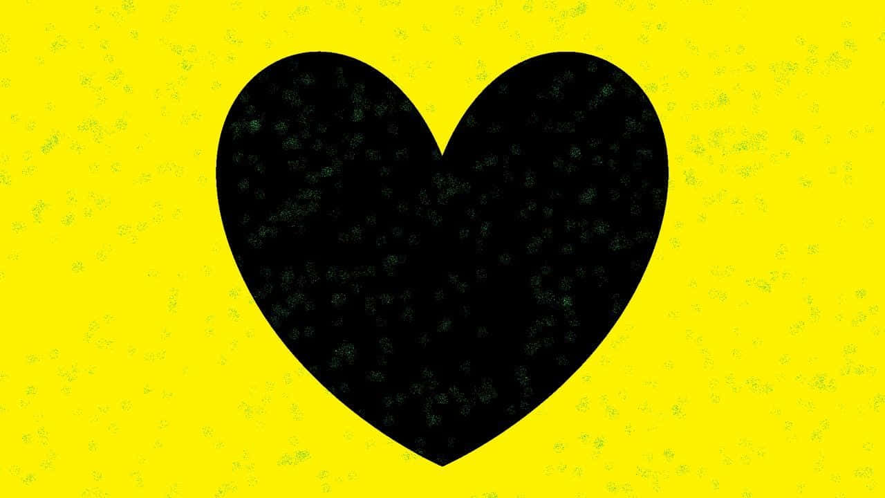 Yellow Heart 桌布 壁紙 — 一個大膽的黑色心形，帶有斑點紋理，置於充滿活力的黃色背景中央，帶有細微的顆粒感。
