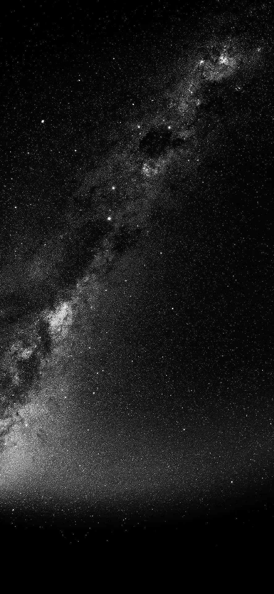 銀河系在繁星點點的夜空中以黑白色彩閃耀。