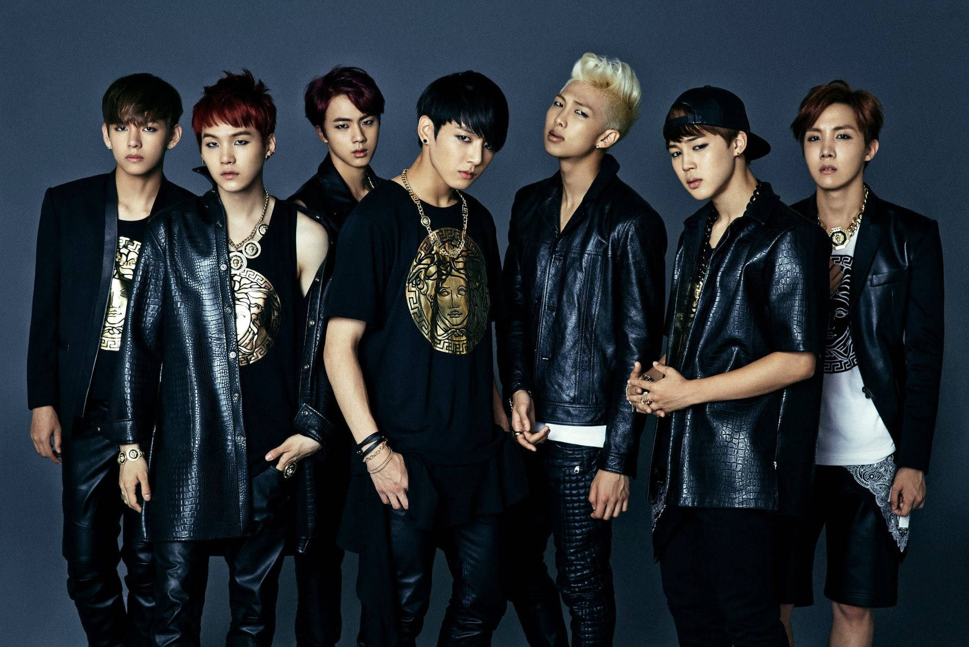 Dark & Wild酷BTS筆電壁紙 壁紙 — 七位時尚年輕男子身穿黑色皮革服裝，在深灰色工作室背景前自信地擺姿勢。