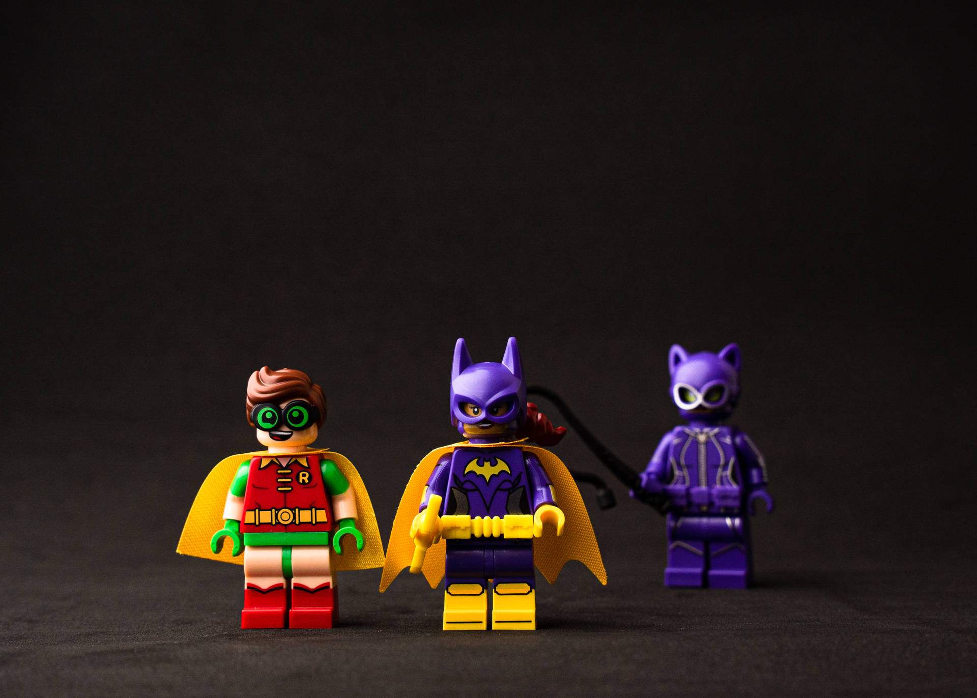 三個LEGO超級英雄人偶羅賓、蝙蝠女和貓女擺姿勢拍照。
