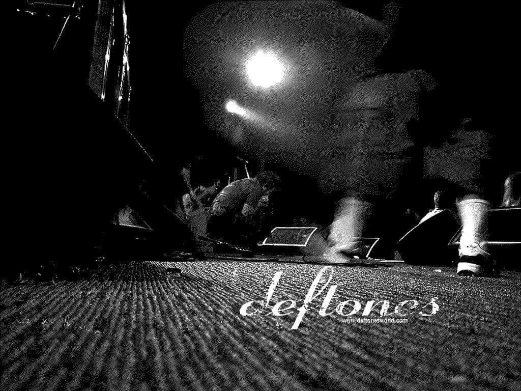 Deftones 研究室高清壁紙 壁紙 — 低角度黑白照片捕捉到一位模糊的音樂家在現場音樂會中於明亮舞台燈光下表演。