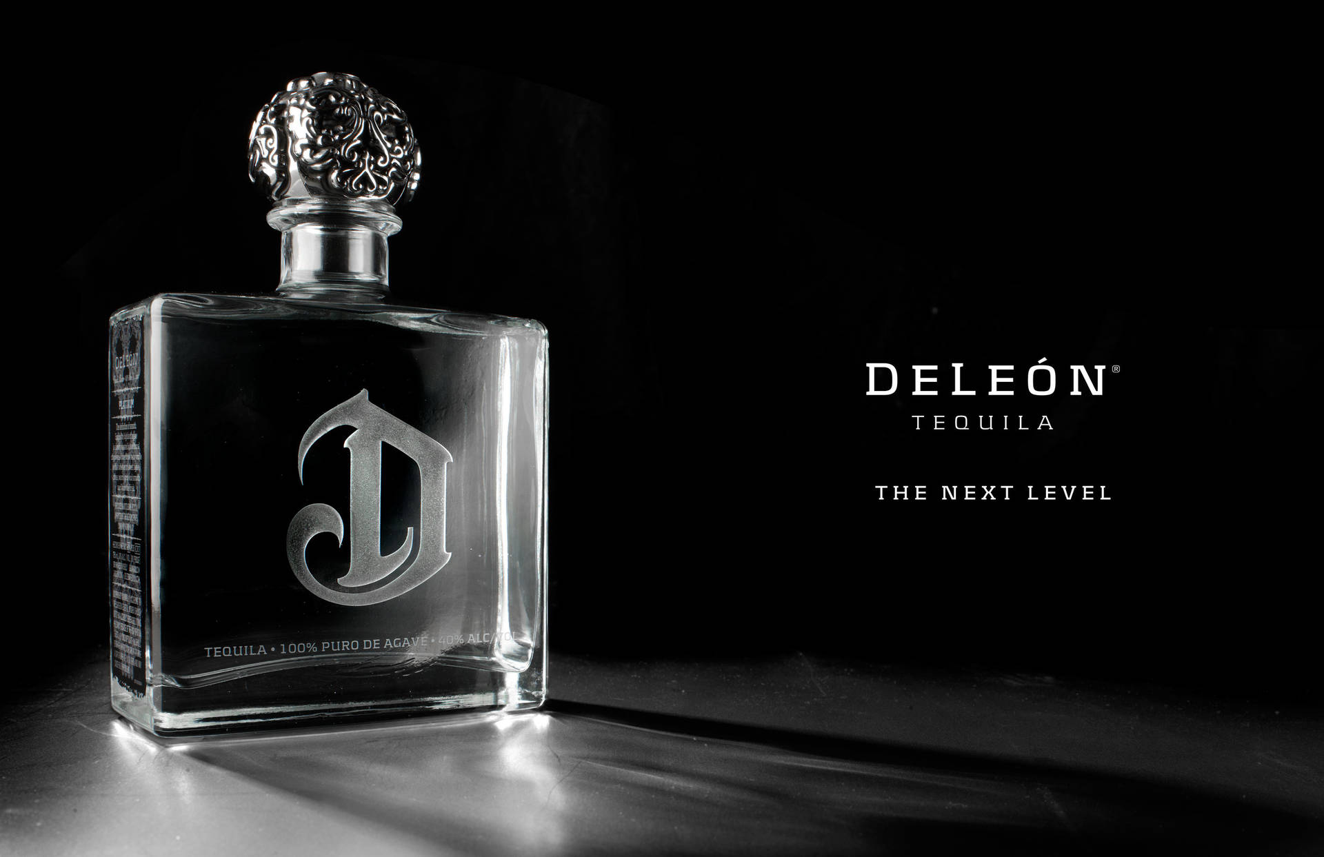 Deleón Tequila 瓶子，銀色瓶蓋，深色表面，帶有品牌文字。