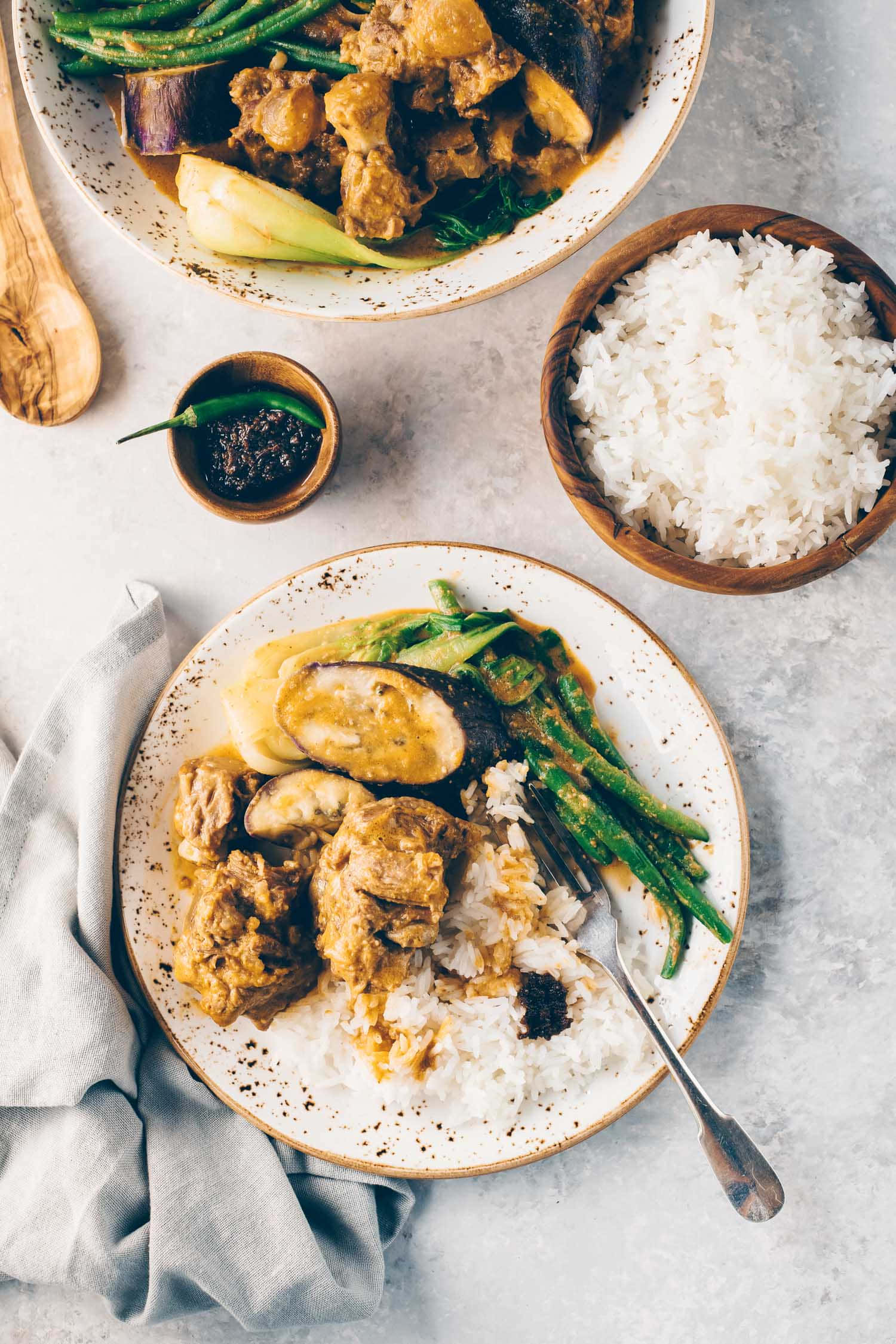 豐盛咖喱牛尾湯——菲律賓美食之 delight 壁紙 — 從上方俯瞰的豐盛咖哩，搭配茄子與四季豆，放在米飯上，附上辣椒醬。