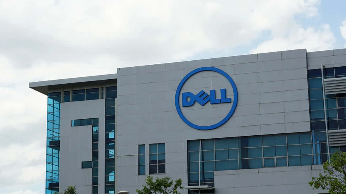 灰色企業建築，帶有藍色Dell標誌和玻璃窗，天空多雲。